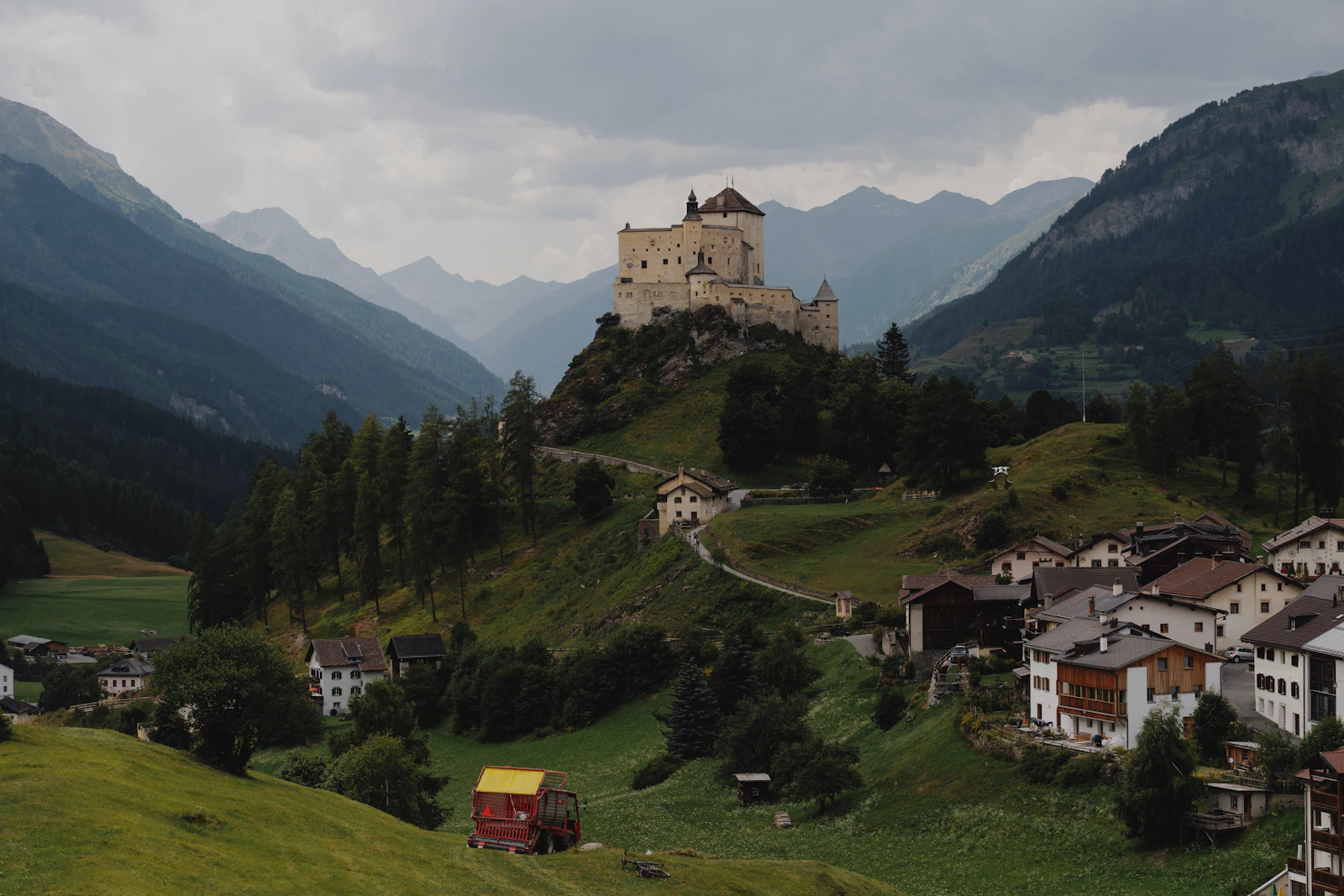 Château perché sur une butte au-dessus d'un village alpin (Tarasp, image d'illustration)