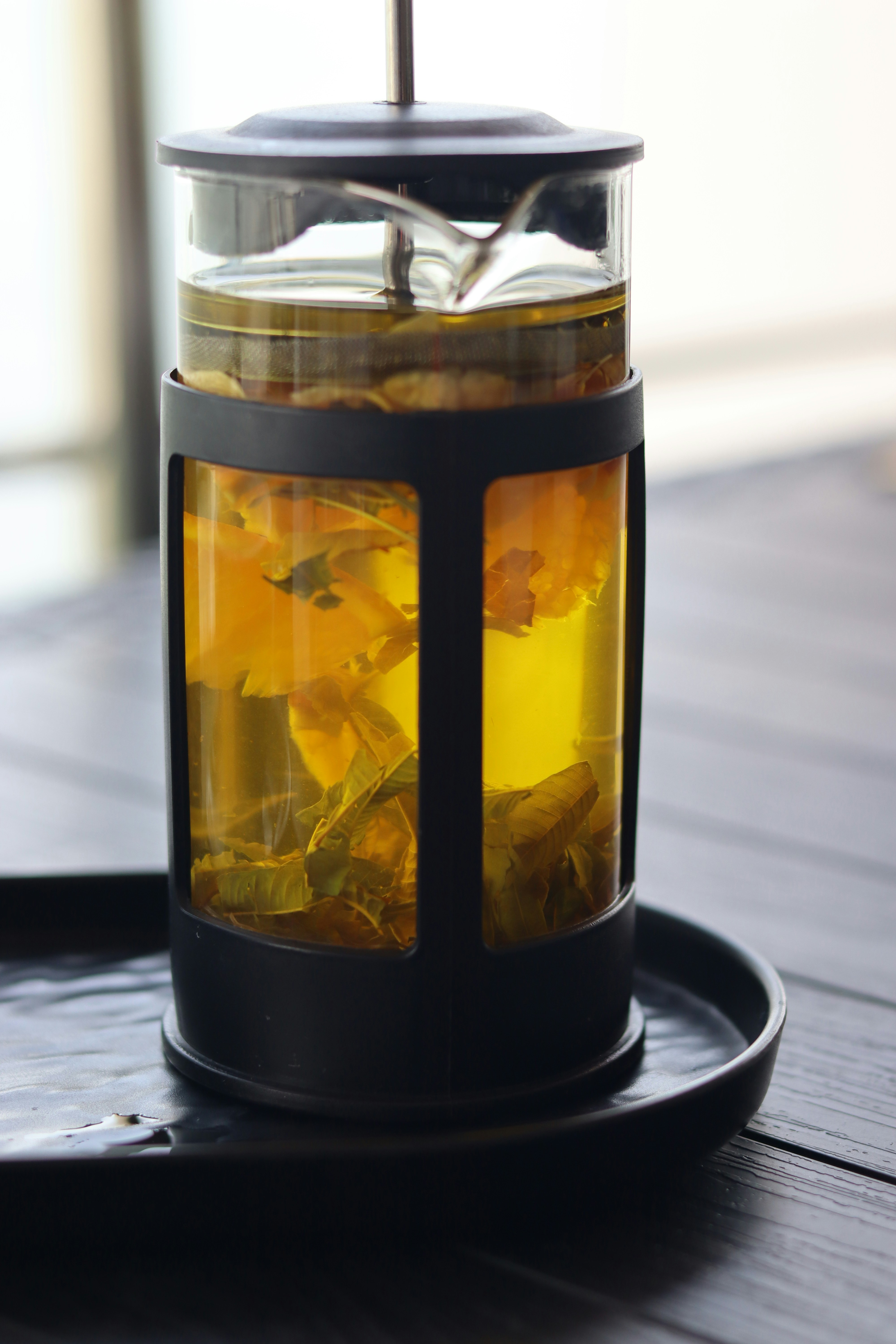 Floral tea is brewing in a french press.