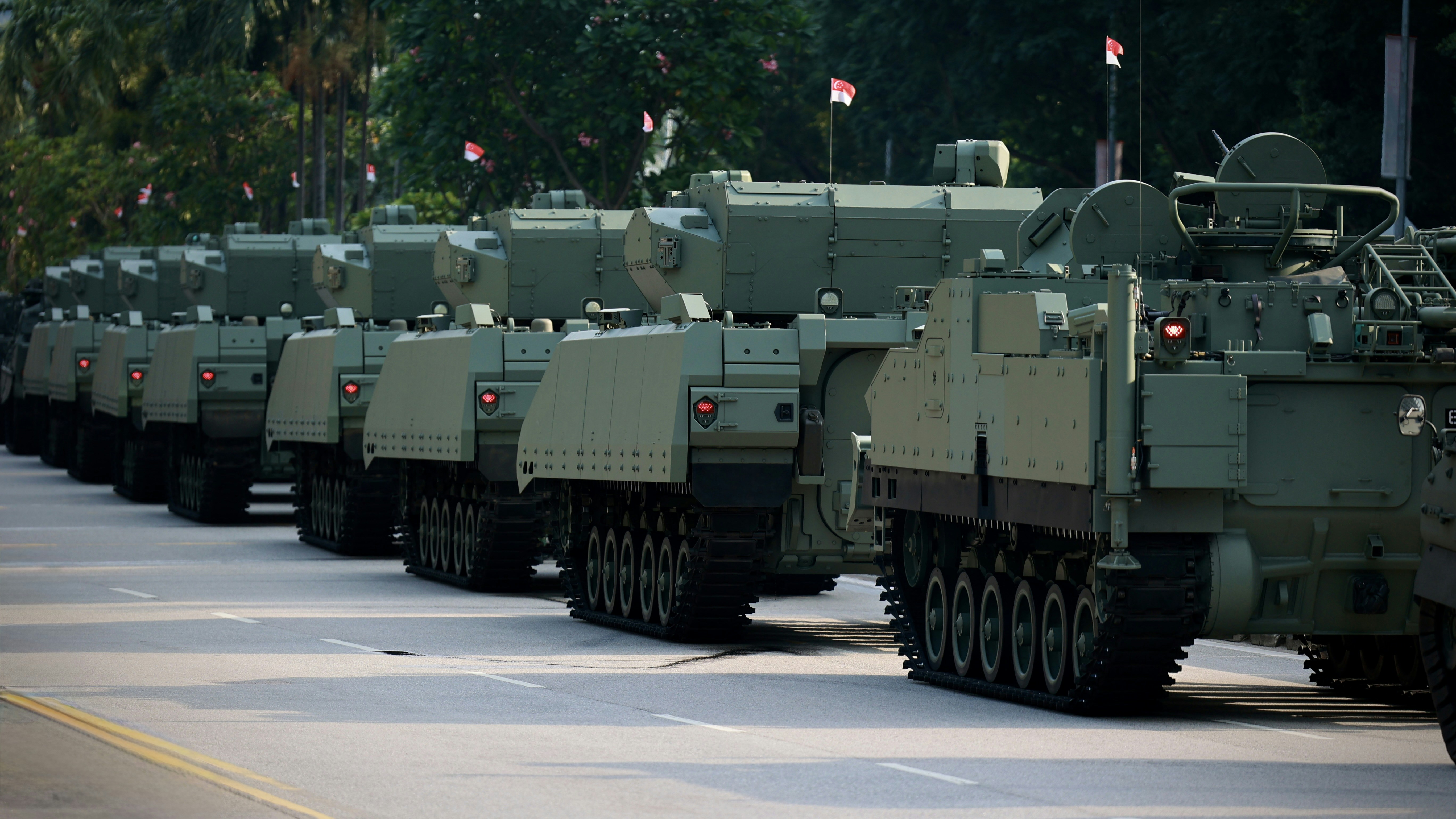 Tanks are parading on a road.