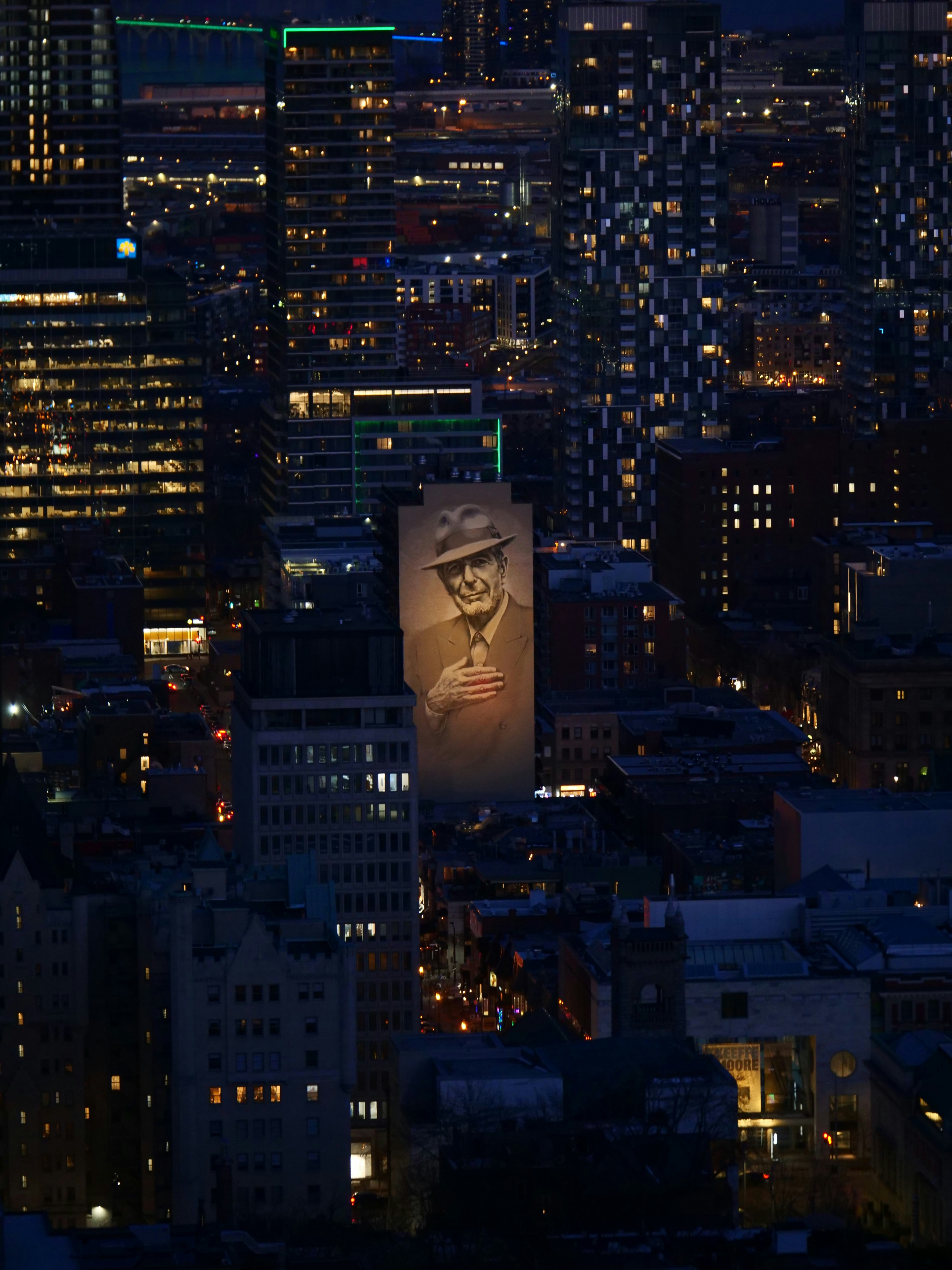 A portrait of a man is projected on a building.