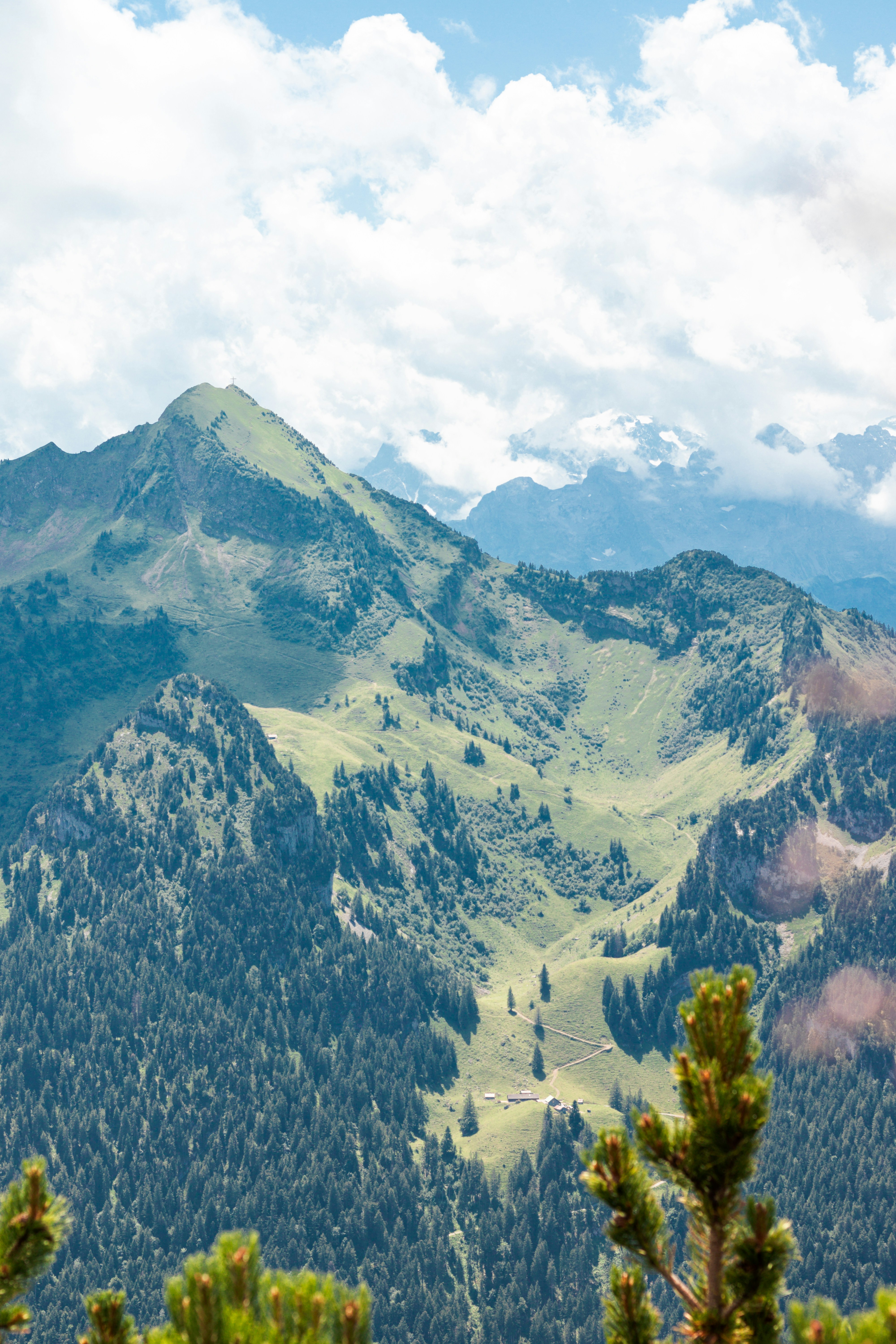 Mountains and forests are seen under a cloudy sky.