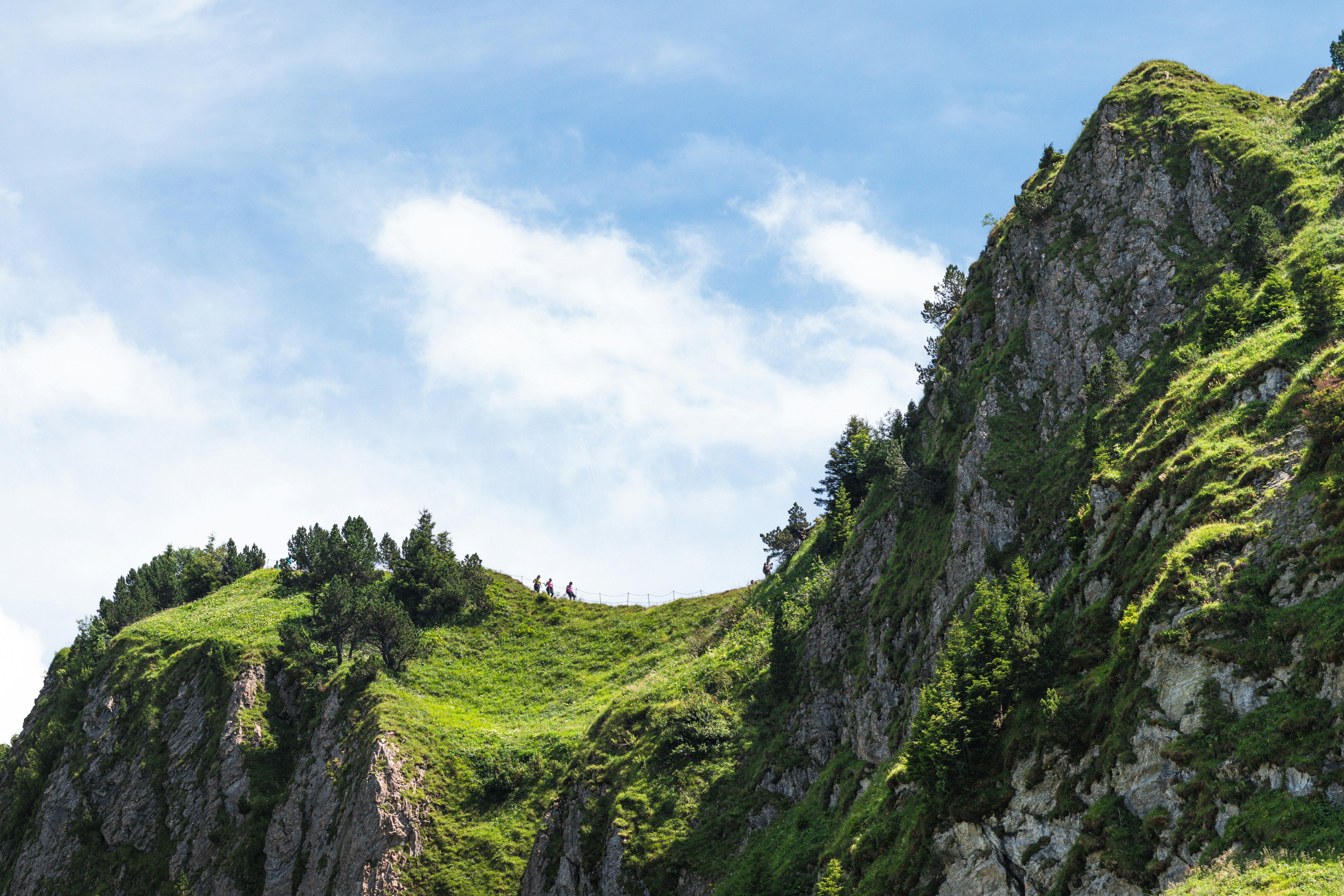Mountain peaks rise beneath a beautiful, cloudy sky.