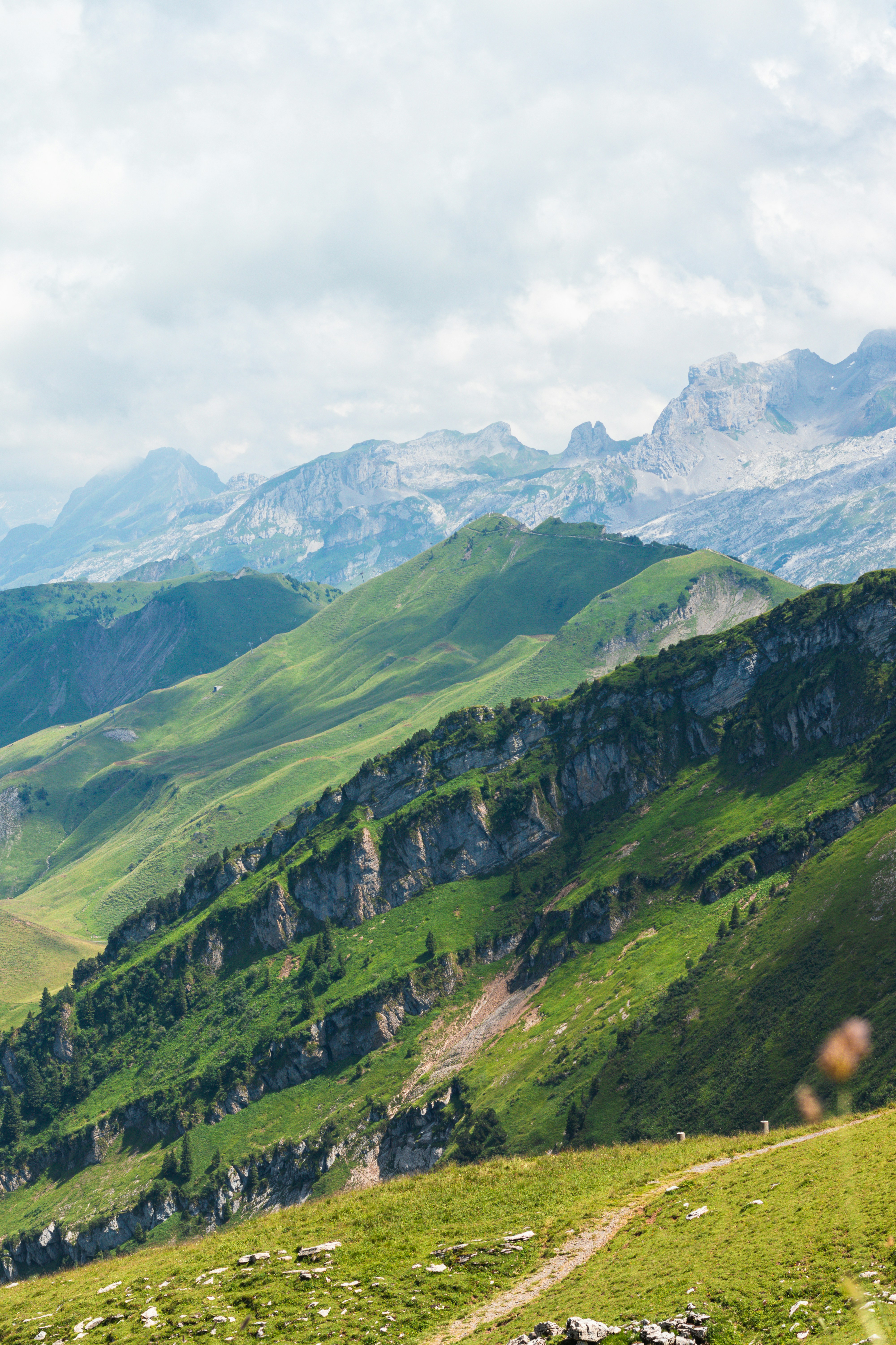 Green mountains roll under a cloudy sky.