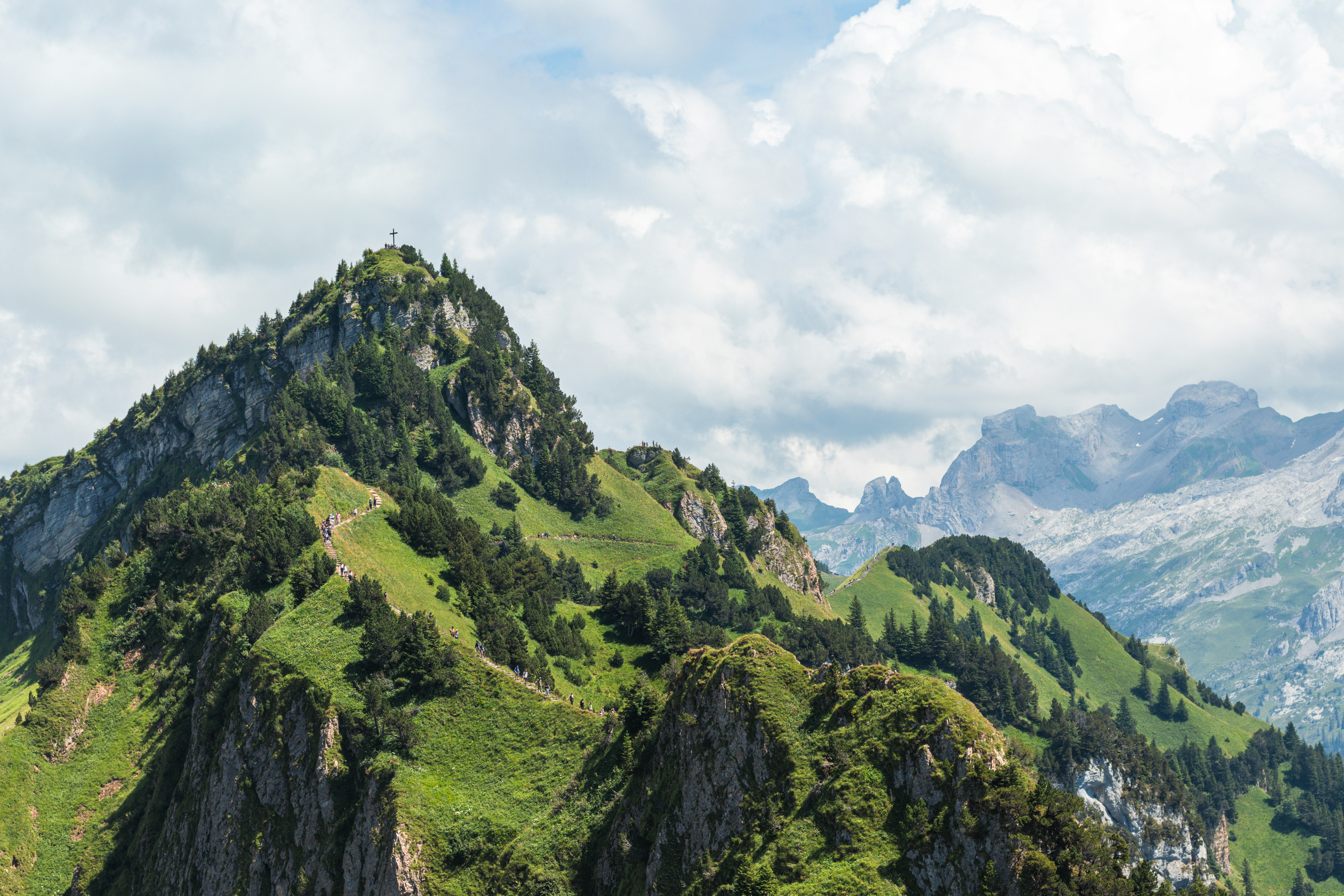 Green mountain peaks rise toward a cloudy sky.