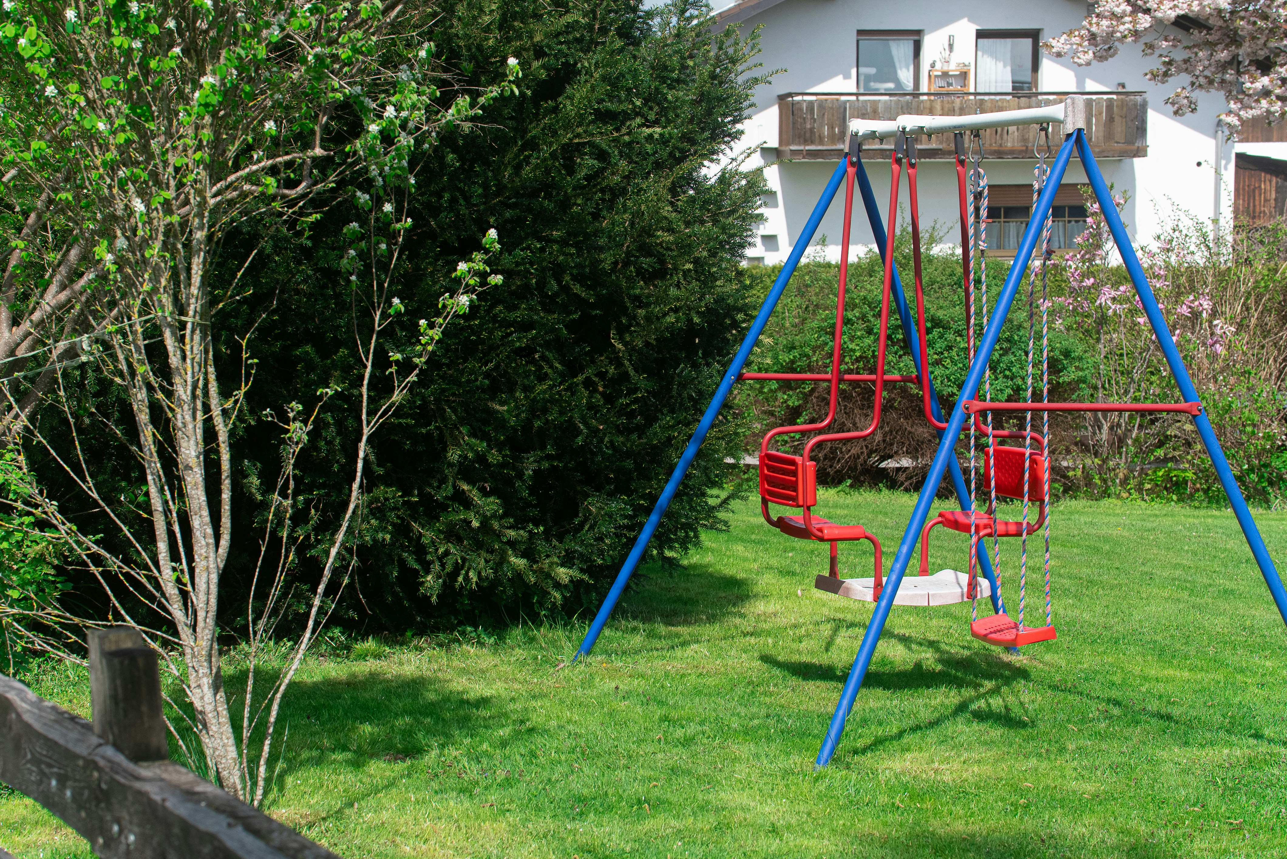 A playground with swings sits in the grass.