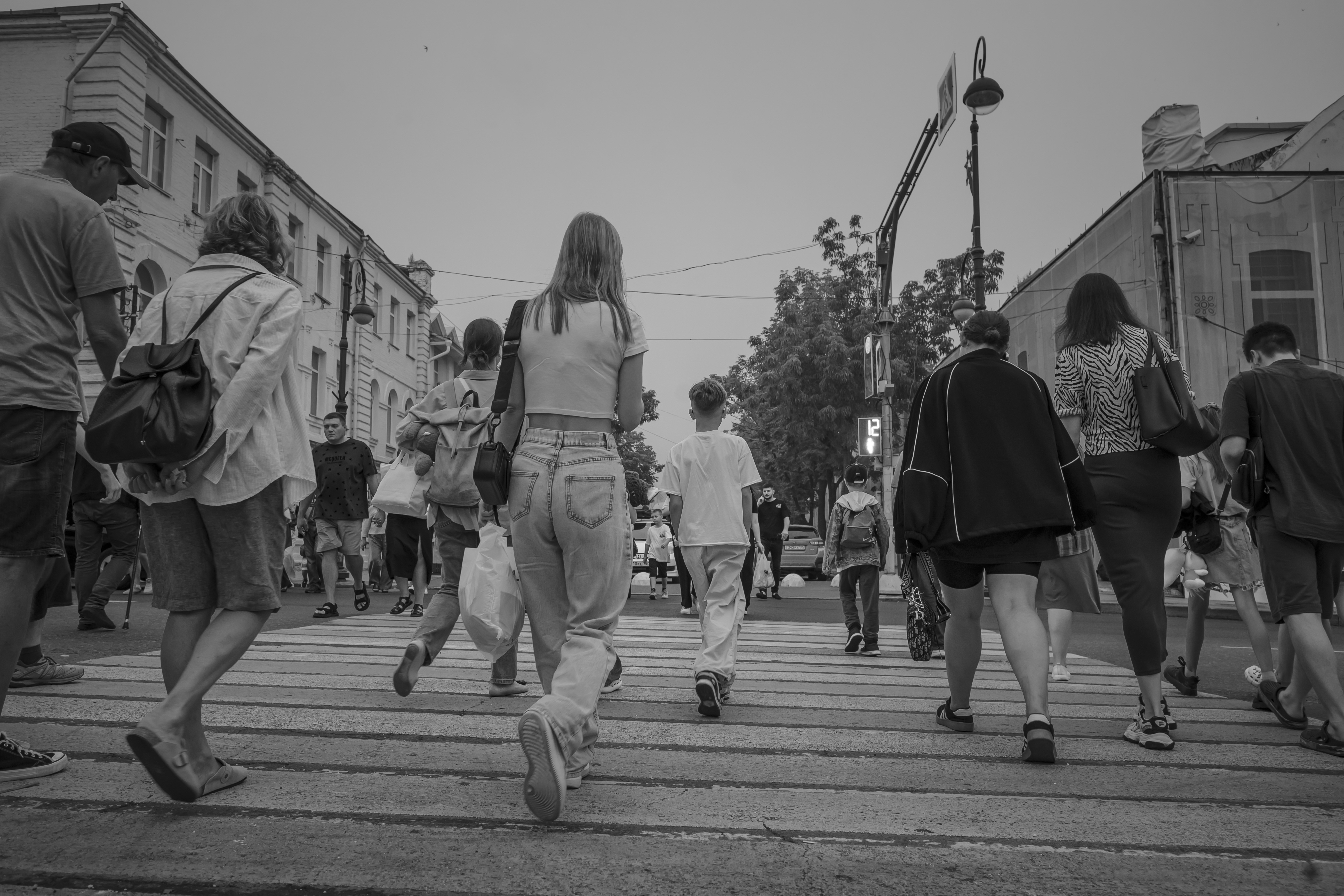 People are walking on a crosswalk in the street.