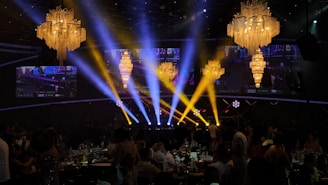 A glamorous event space with chandeliers and spotlights.