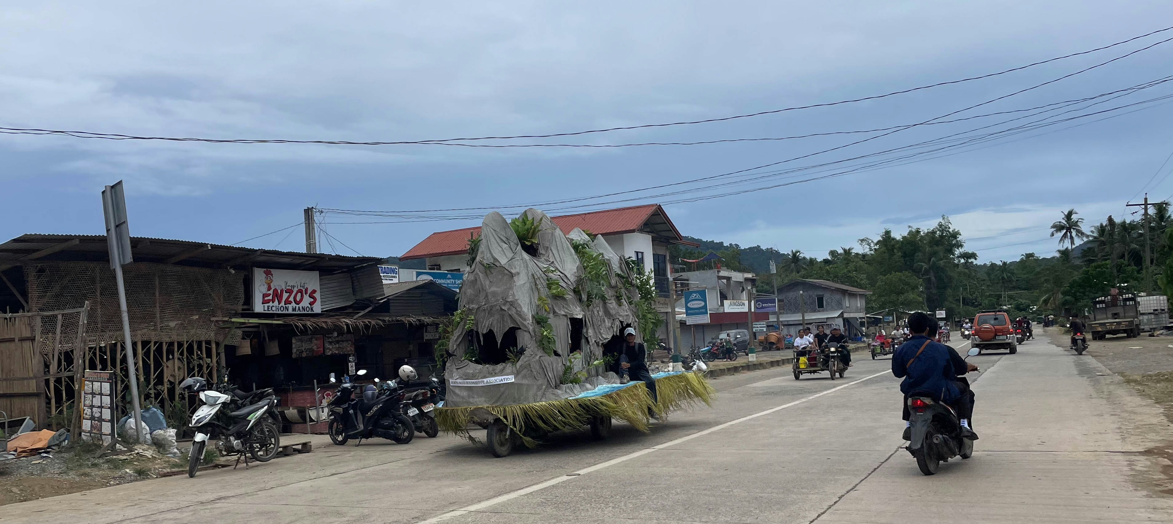 A dinosaur float rides down the road.