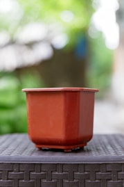 A brown plant pot sits on a table.