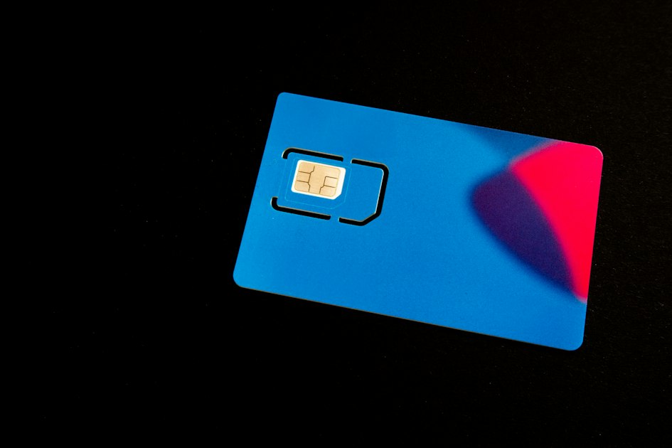 A blue SIM card with gold chip on a dark background, representing eSIM technology.