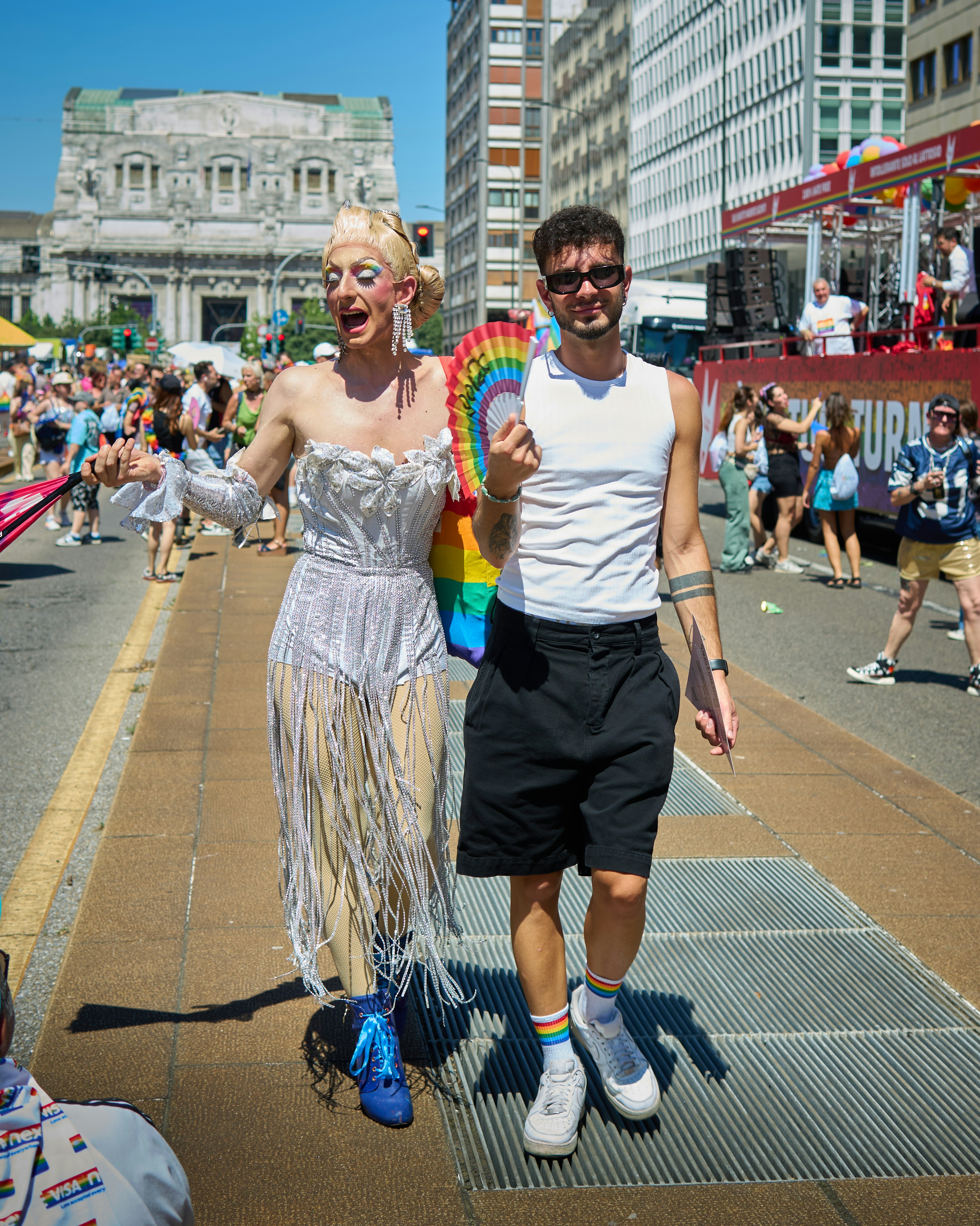 Two people happily march during a pride parade.