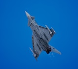 An aircraft soars through the bright blue sky.