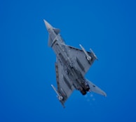 An aircraft soars through the bright blue sky.