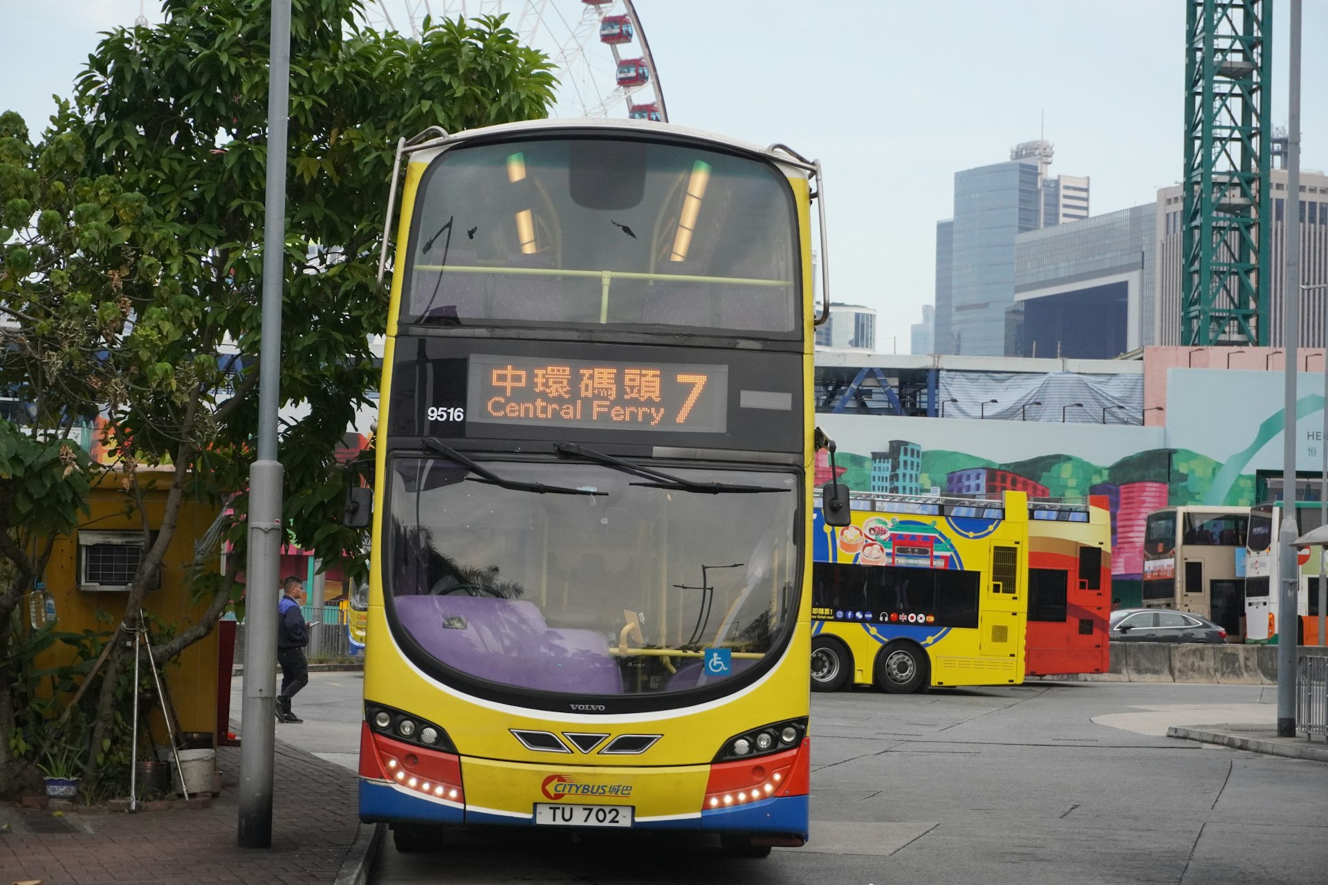 A yellow double-decker bus is stopped on a street.