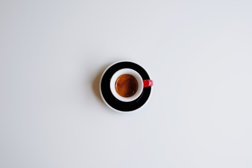 Here's a short caption: a shot of espresso in a tiny cup.