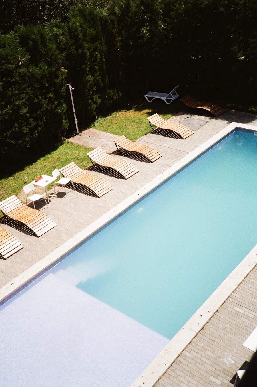 Large clean pool with lounge chairs alongside