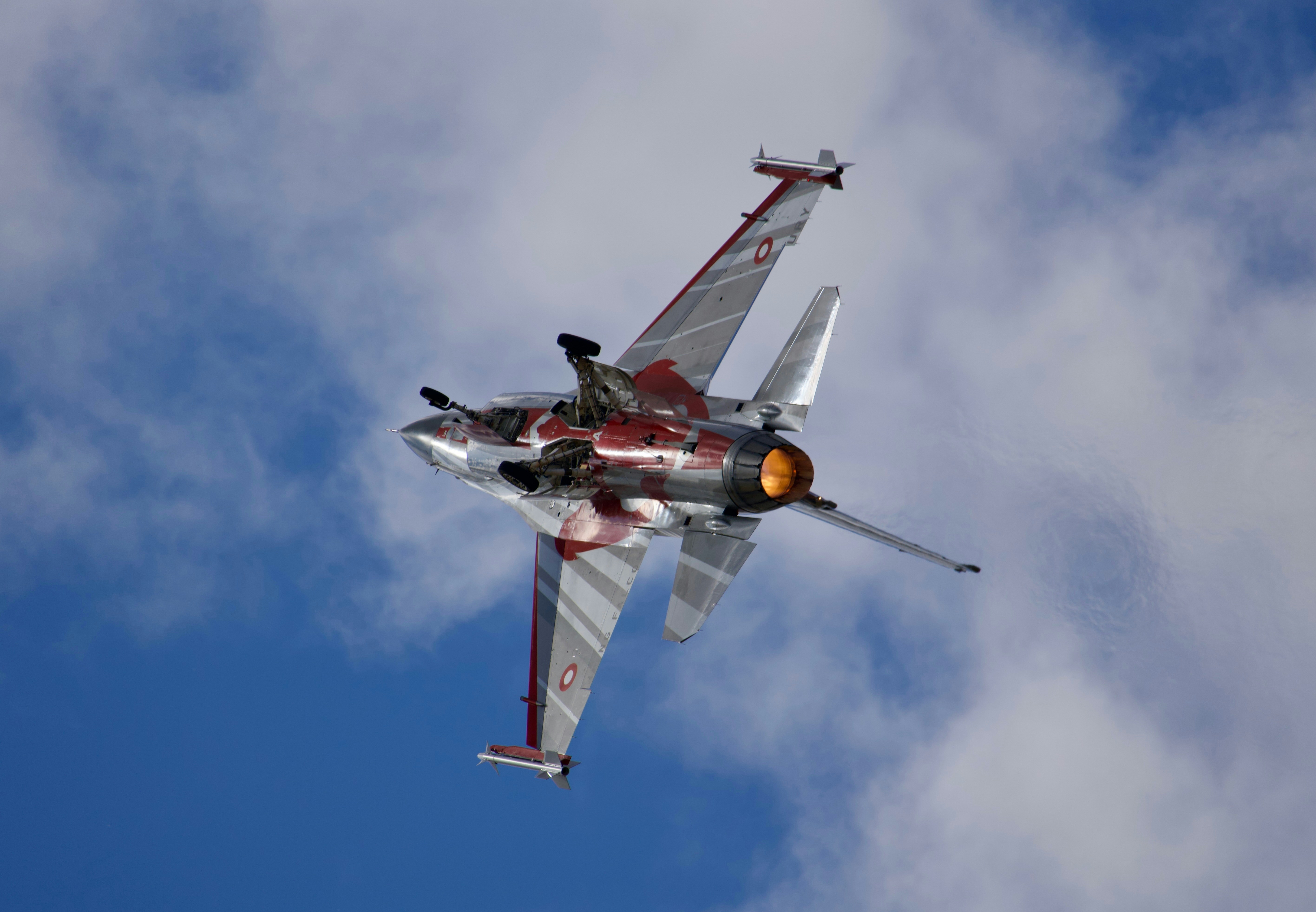 曇り空の間をジェット戦闘機が飛んでいます。