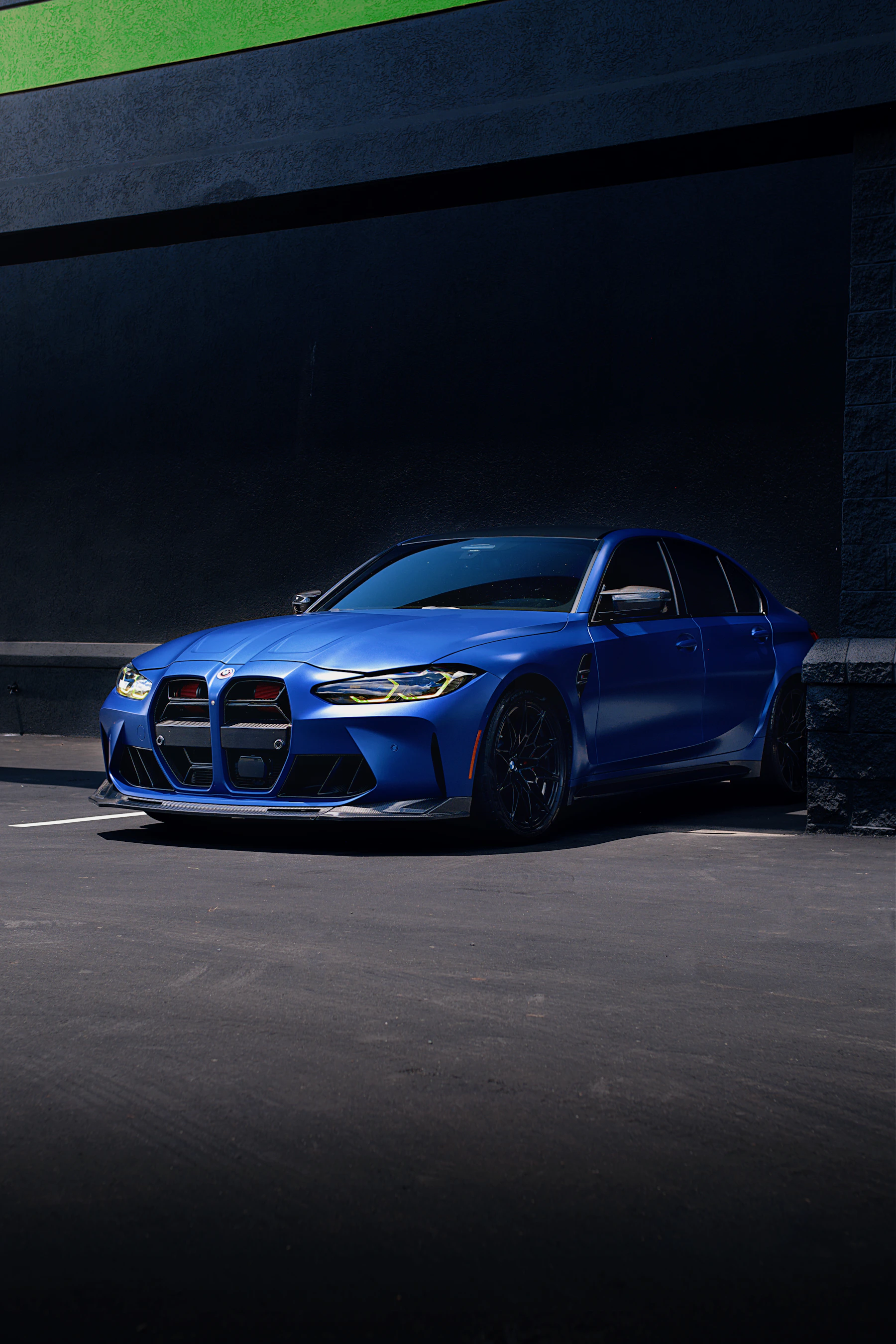 Blue BMW M3 G80 parked in sunlight