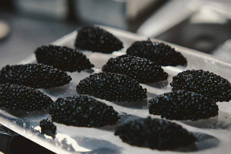 Black, textured food is arranged on a tray.