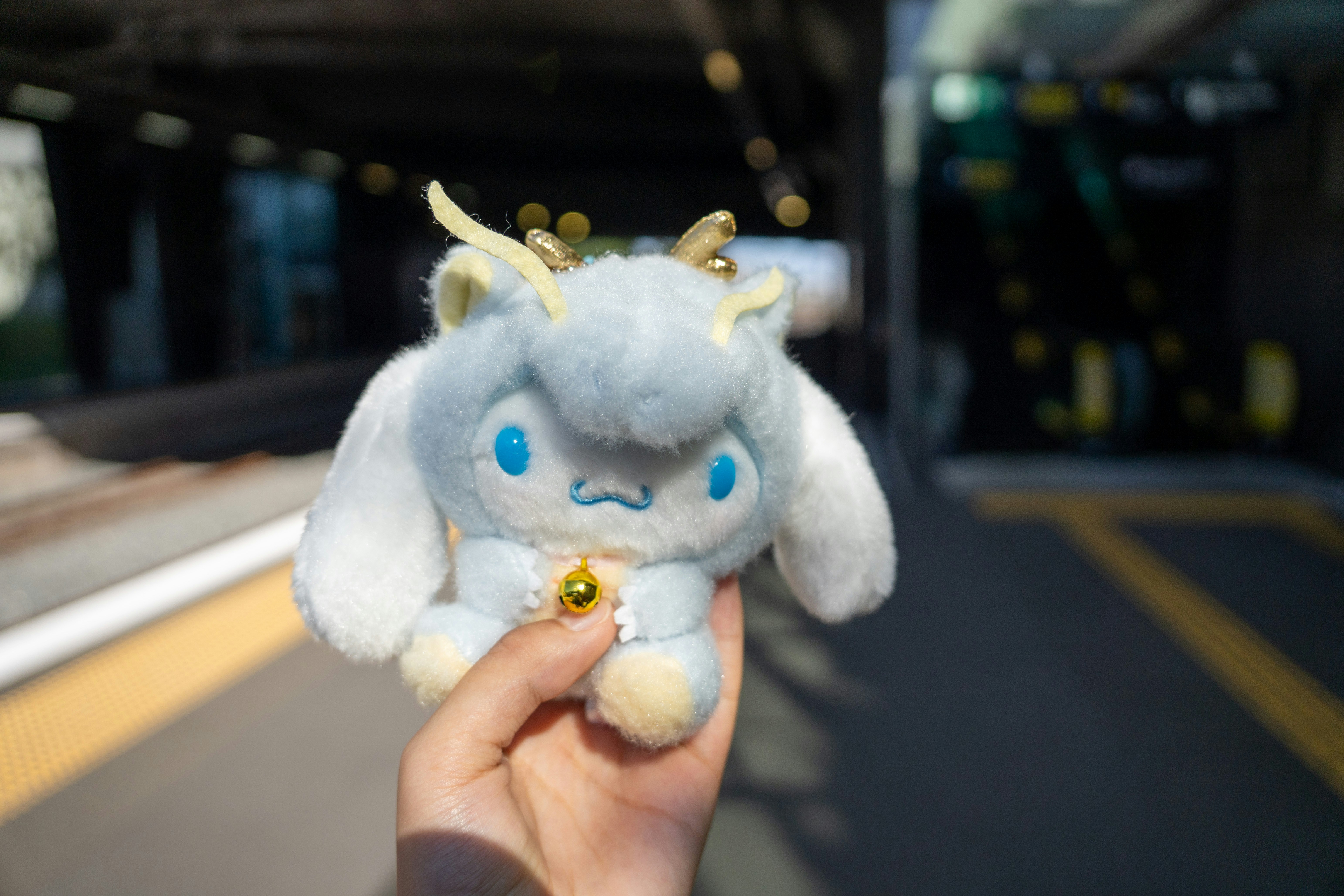 A person holds a cute dragon plush toy.