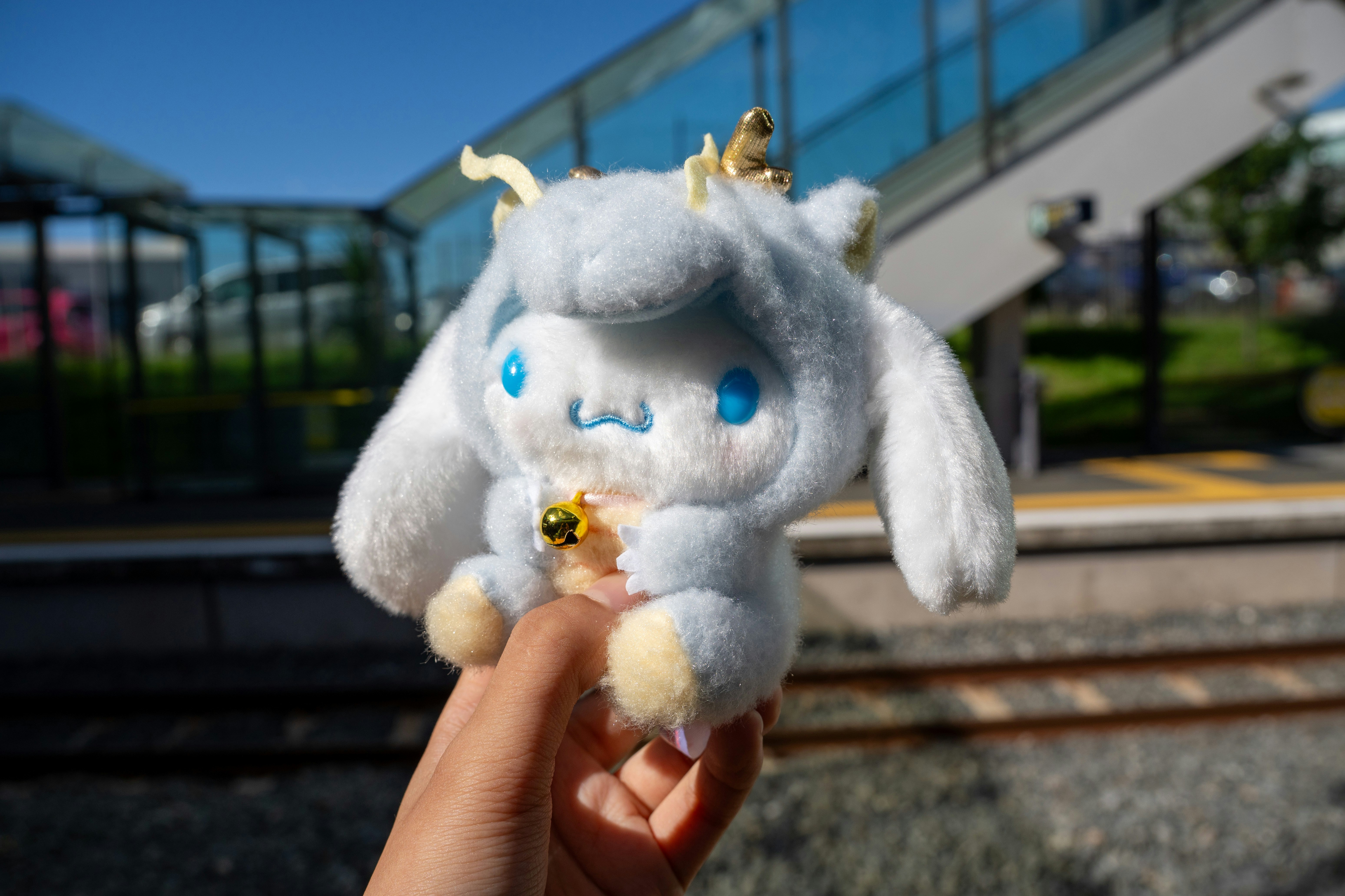 A hand holds a plush cinnamoroll doll.