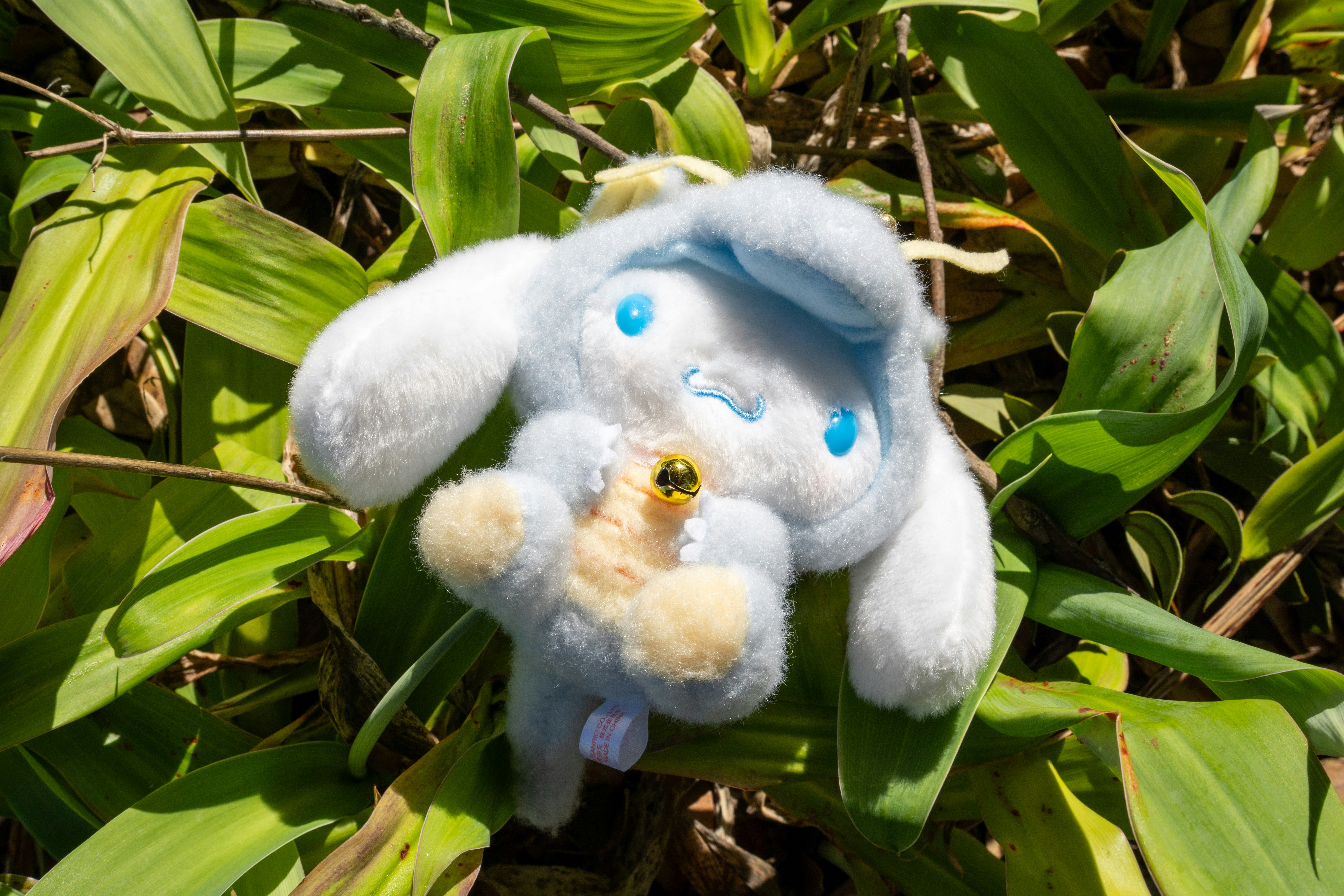 Cinnamoroll plush nestled amongst greenery.