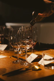 Wine is being poured into glasses on a table