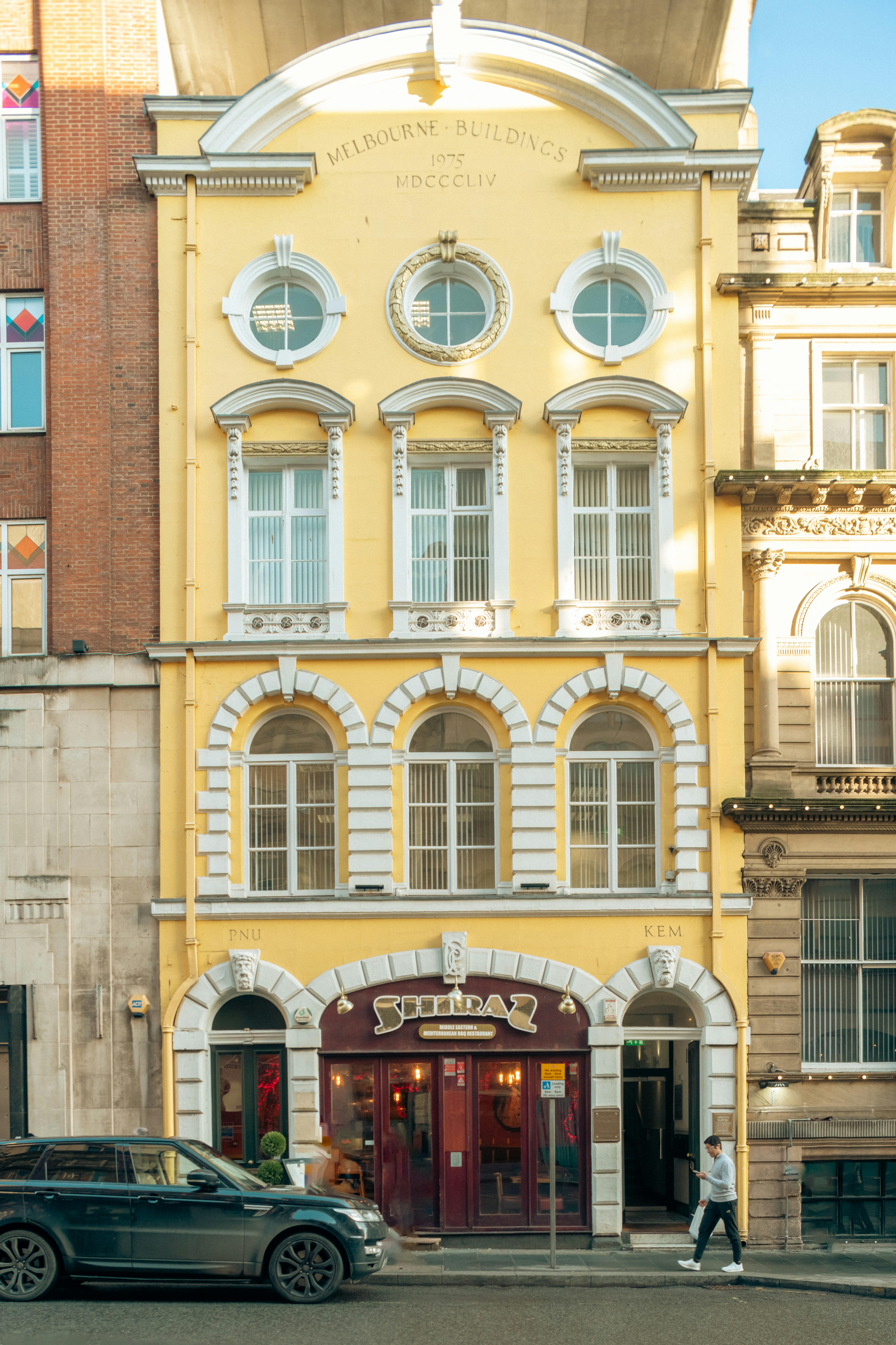 Yellow building with a pub on the ground floor.