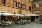 Restaurant tables sit outside a building.