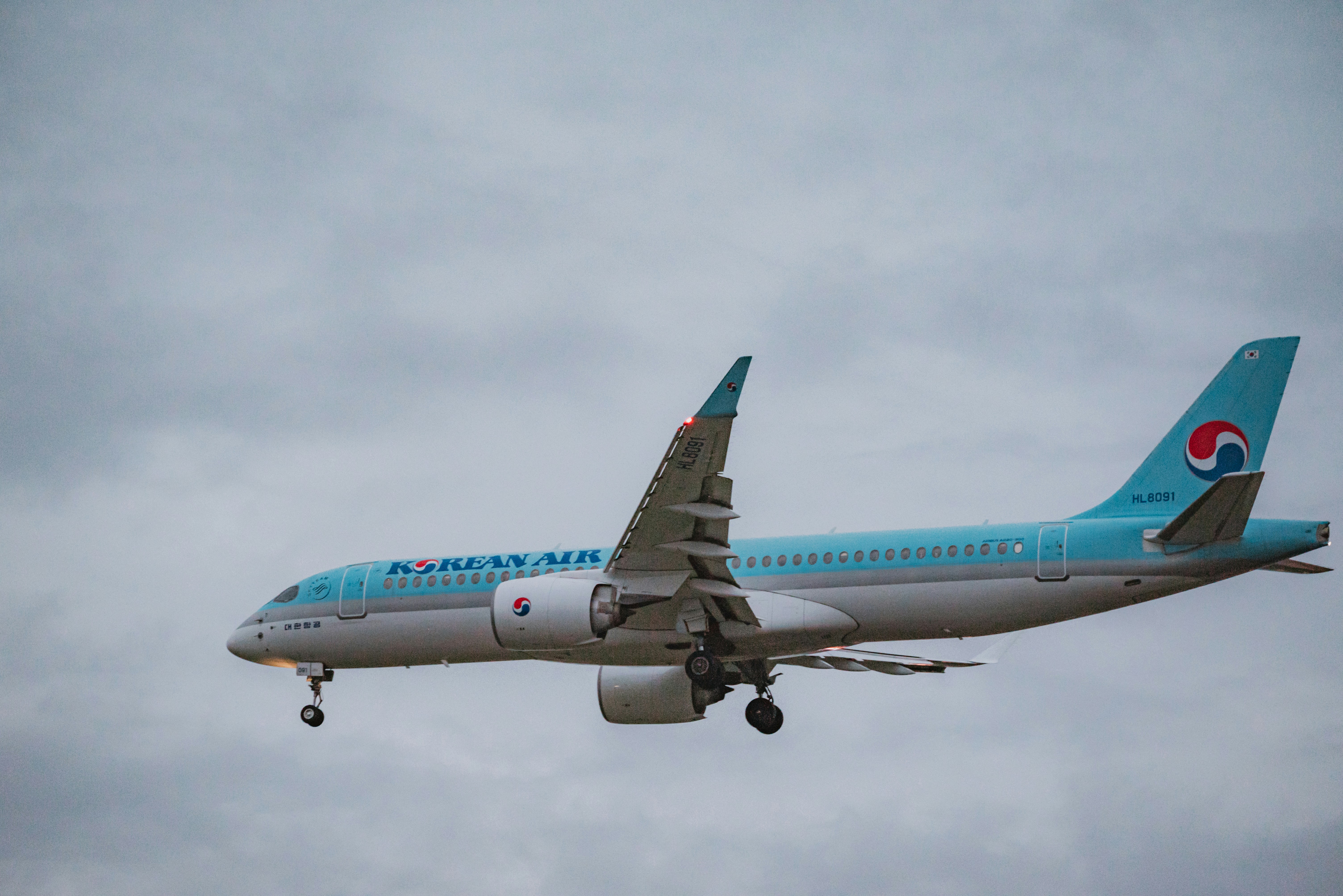 An airplane is flying in the cloudy sky.