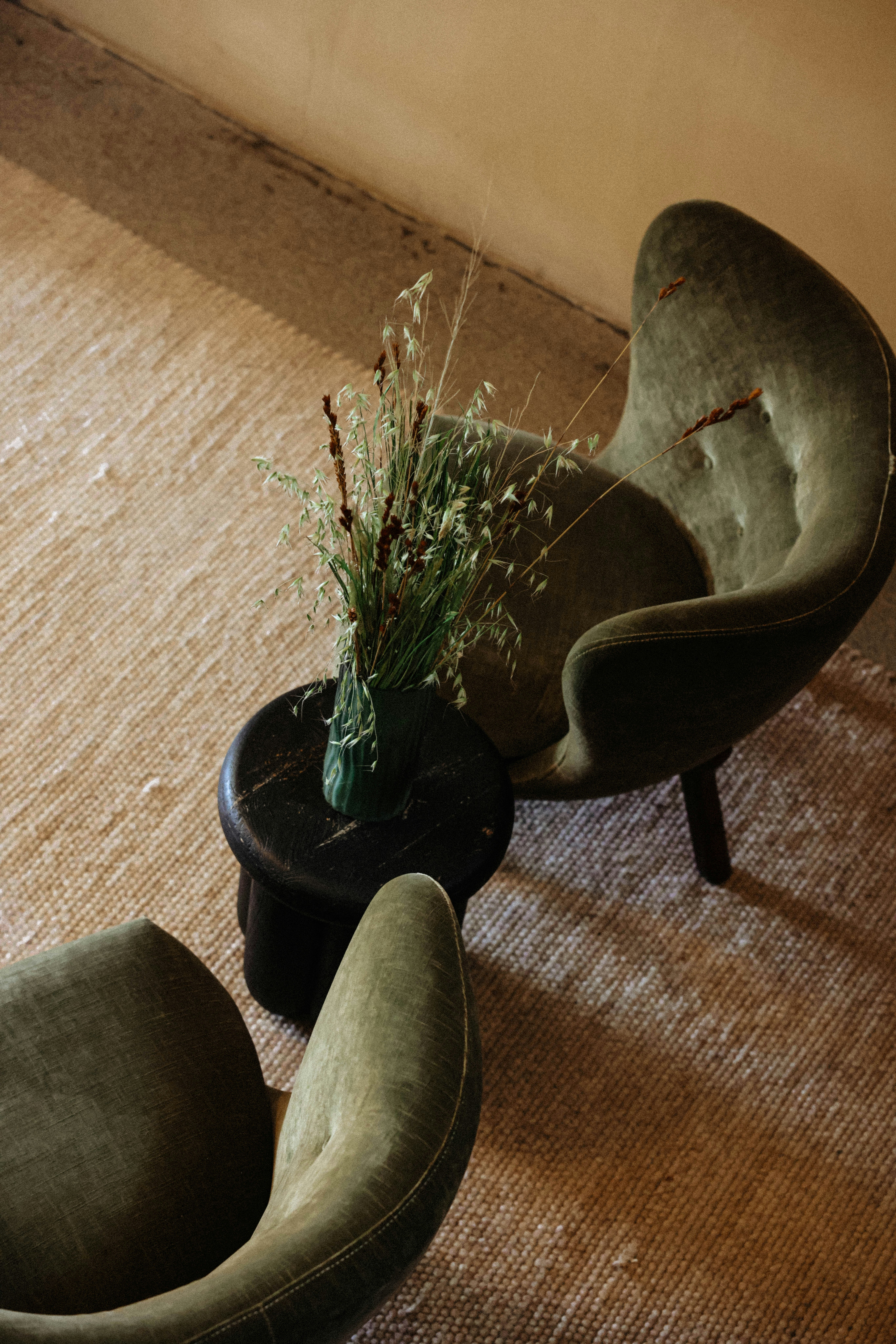 Two green chairs flank a small table.