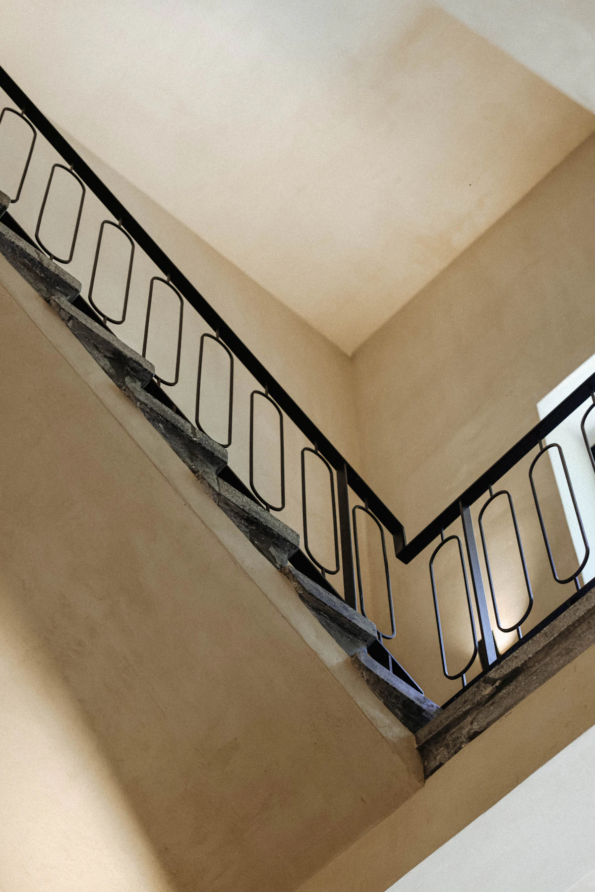 A staircase with a black handrail, the route through a building.
