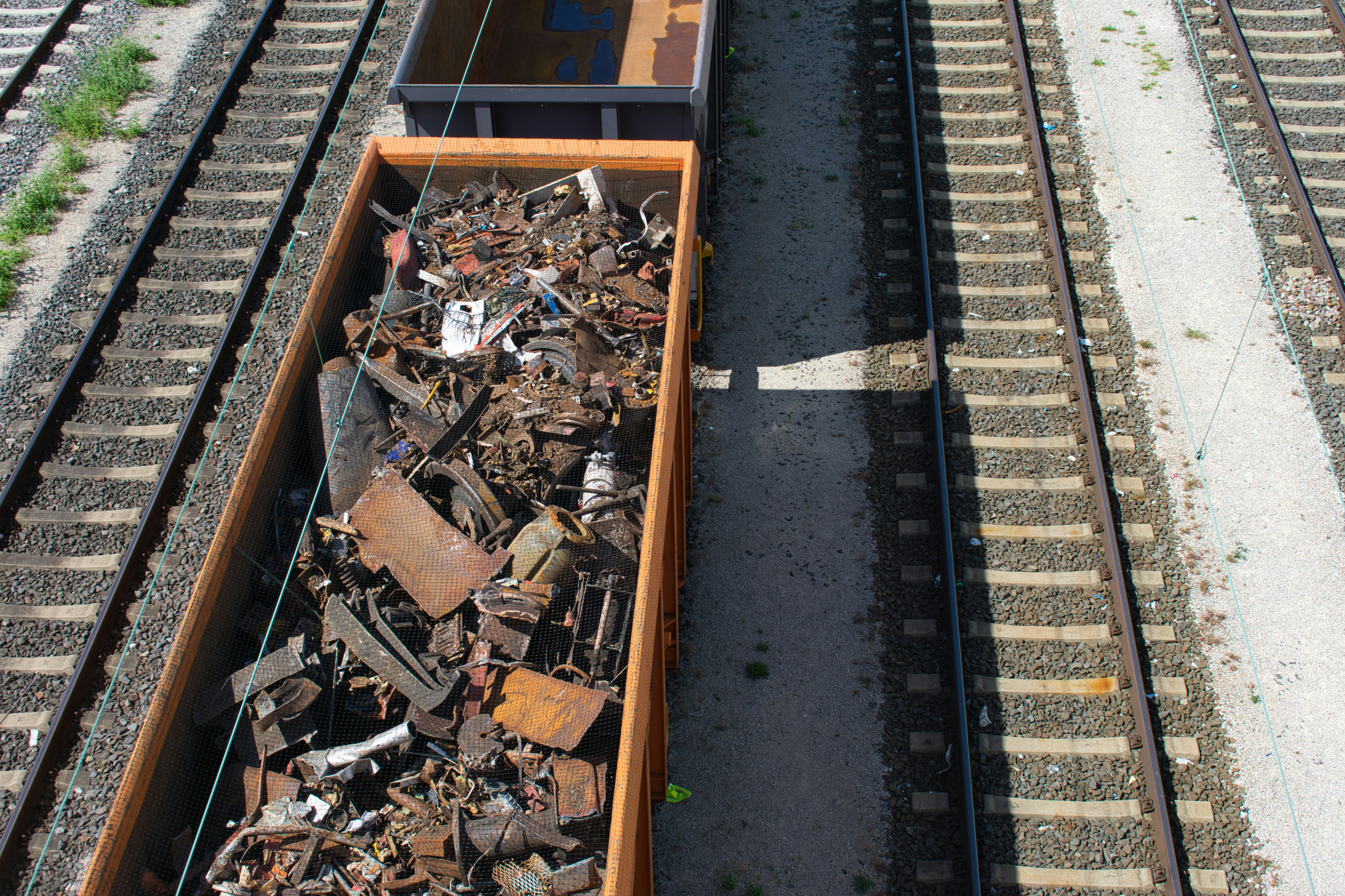 Train cars filled with scrap metal are shown.