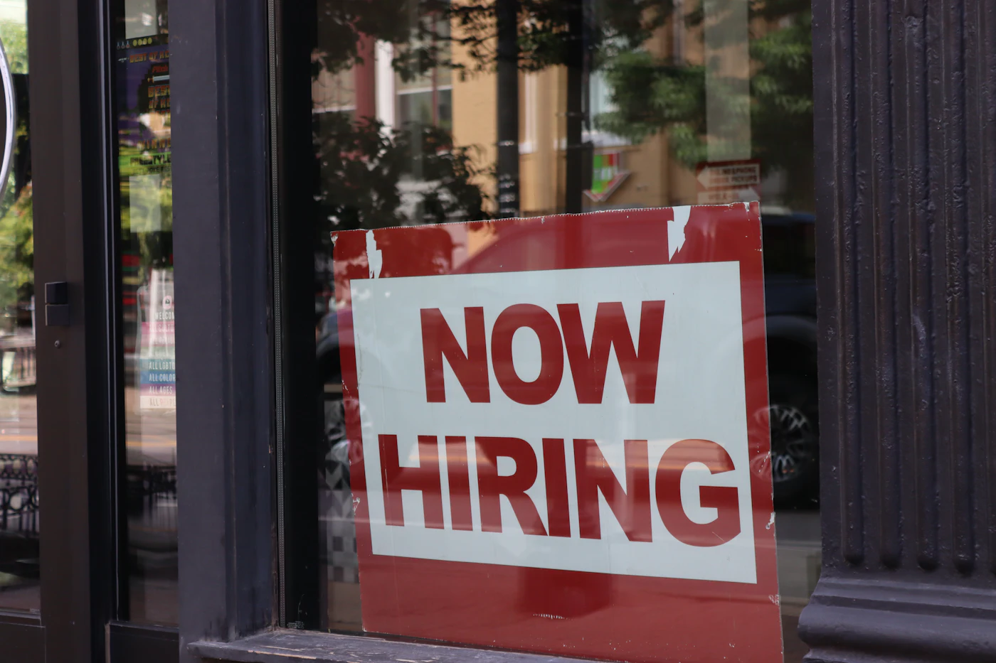 A "now hiring" sign in a store window