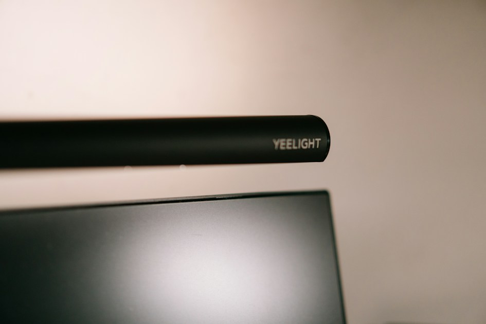 Monitor light bar mounted above a computer screen lighting up a desk setup