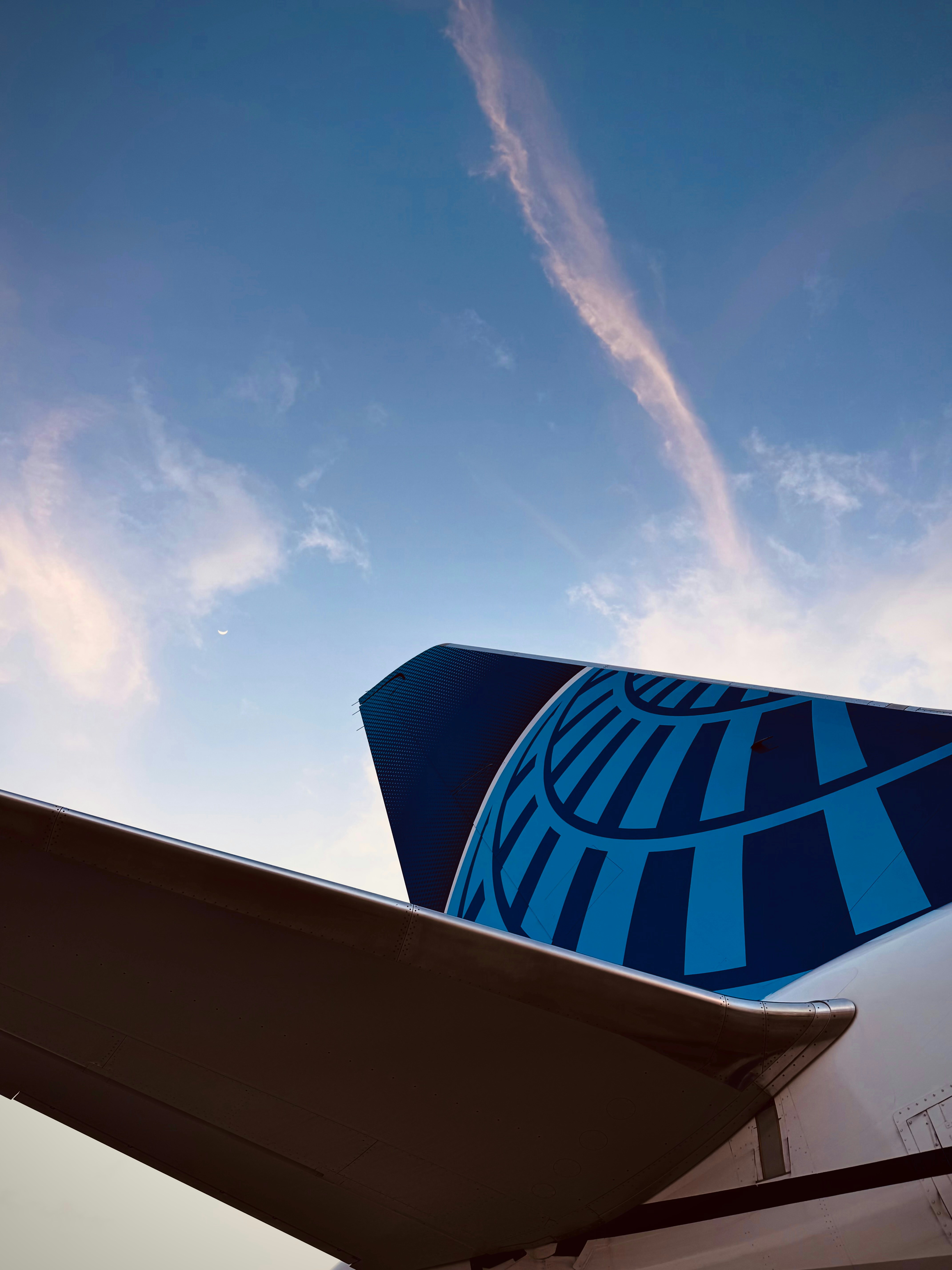 United airlines tail fin against a blue sky.