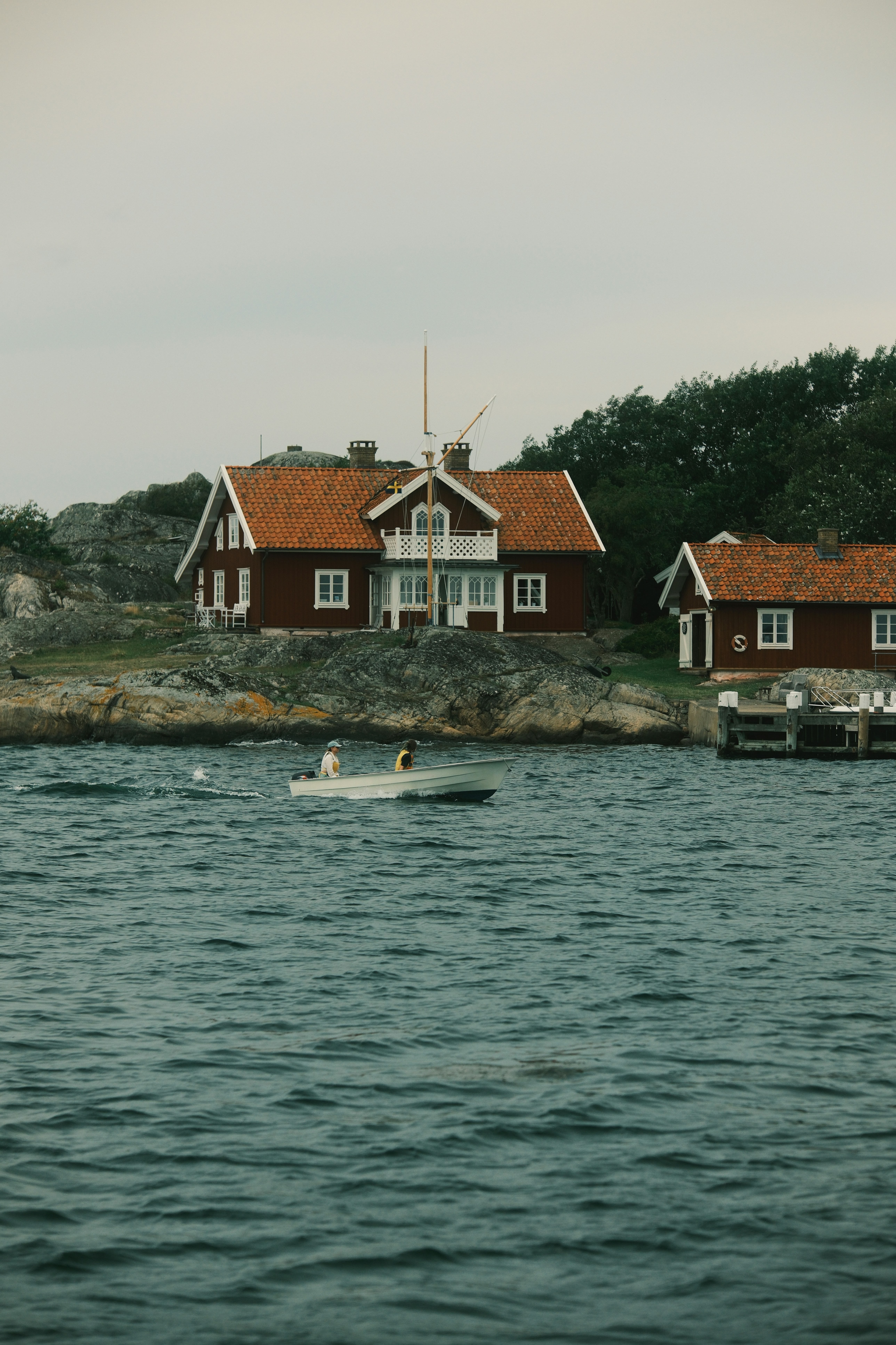 Houses near the sea, with a small boat in between.