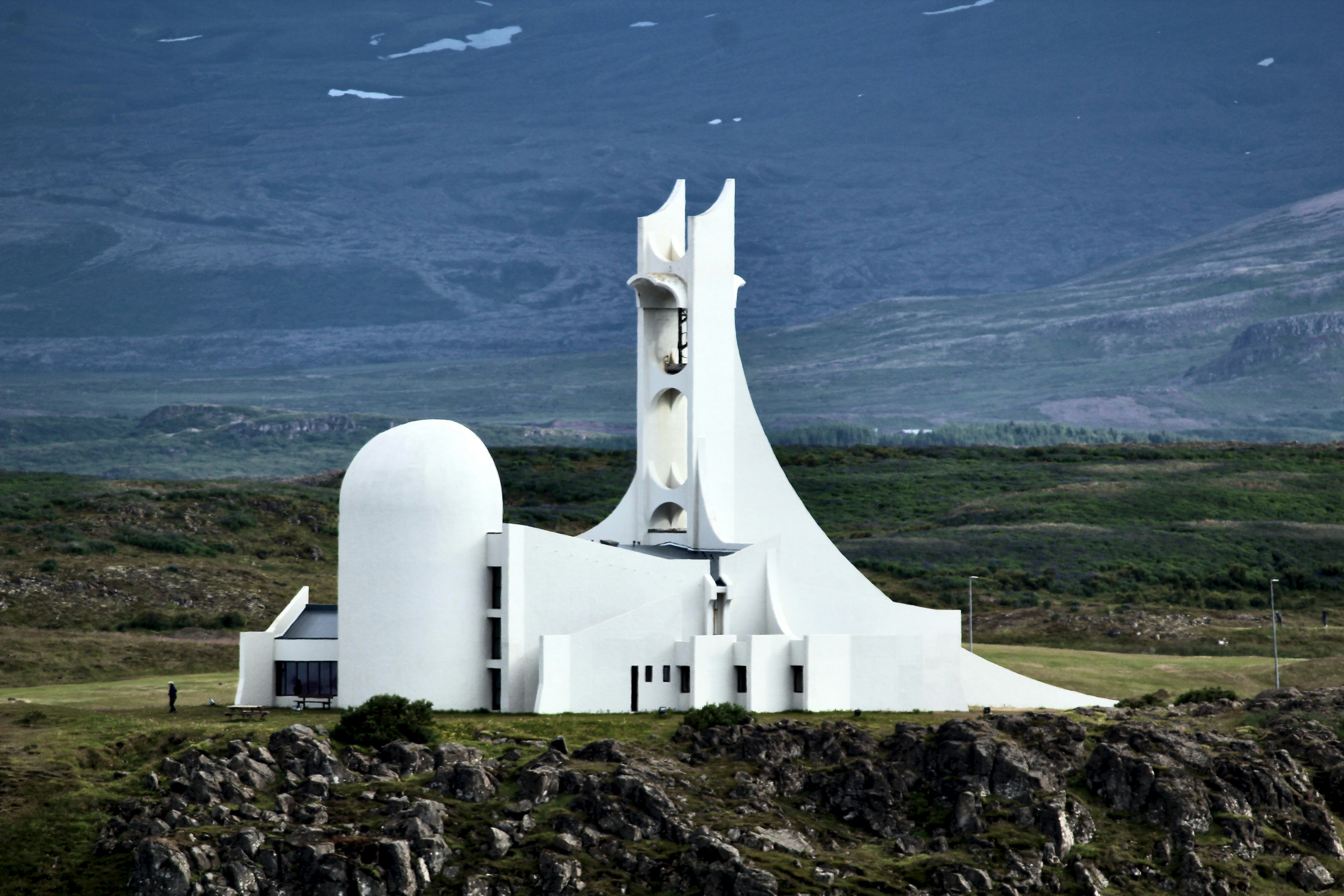 A striking, modern white church stands against the hills.