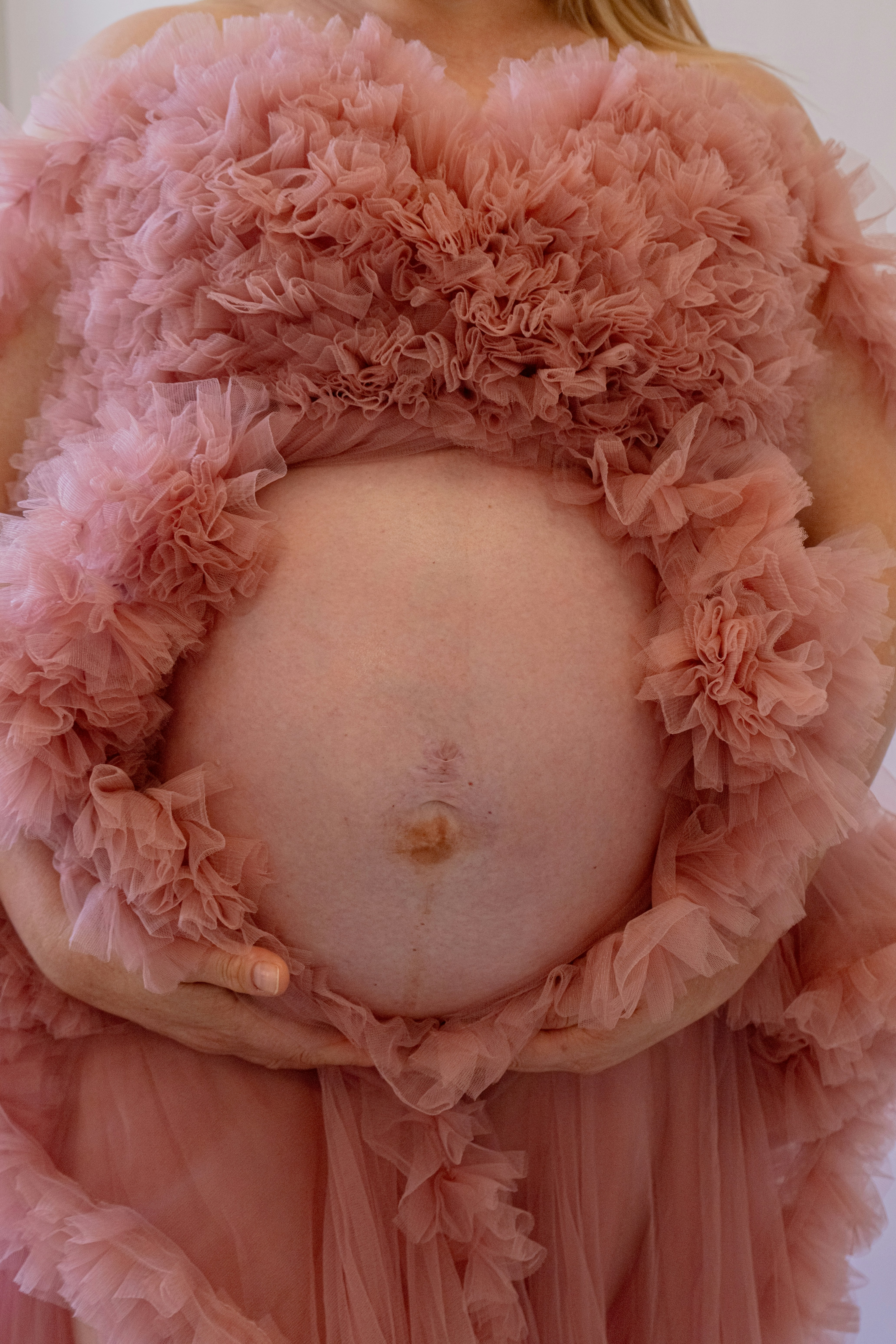 A pregnant woman holds her belly.