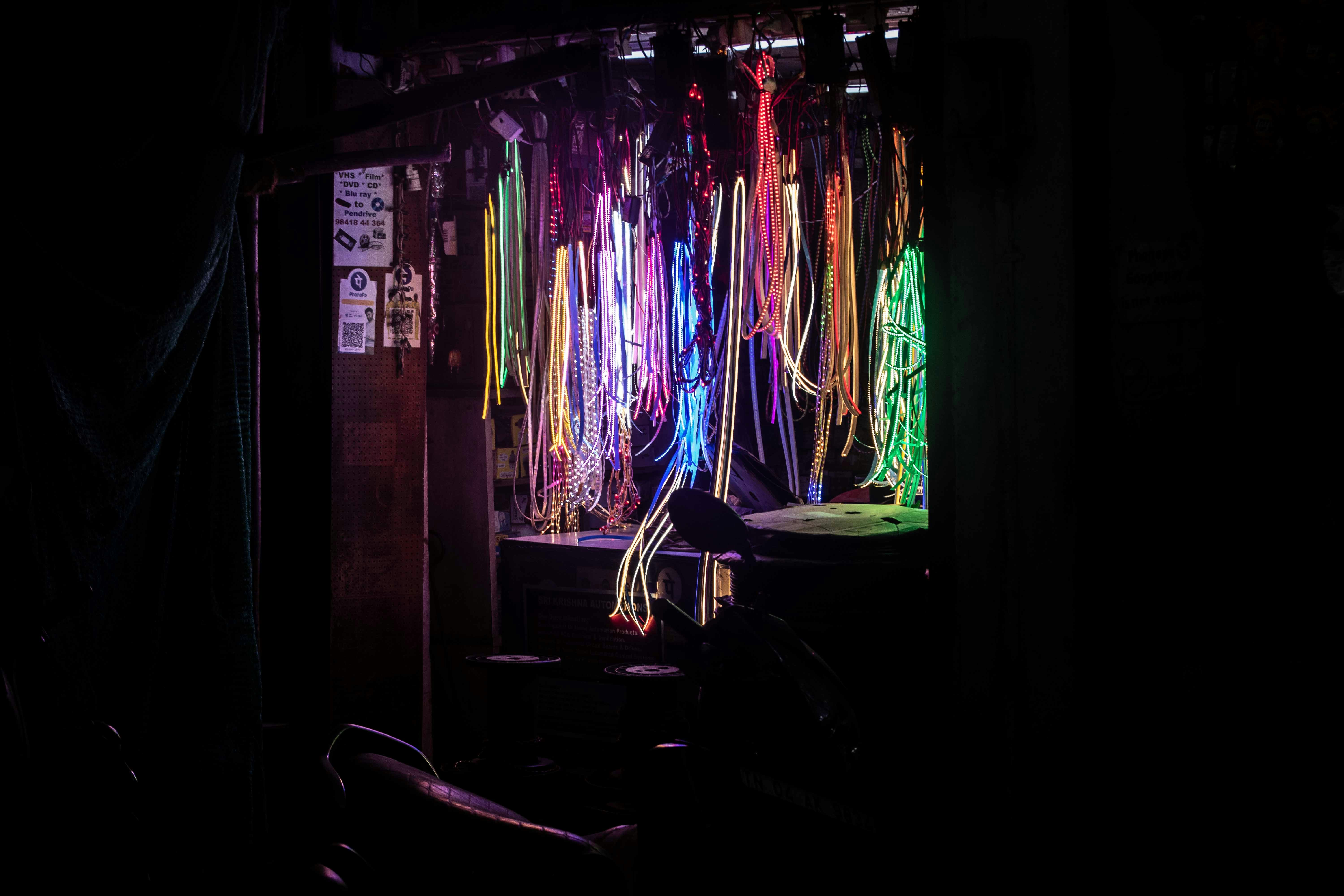 Colorful ribbons hang in a dimly lit room.