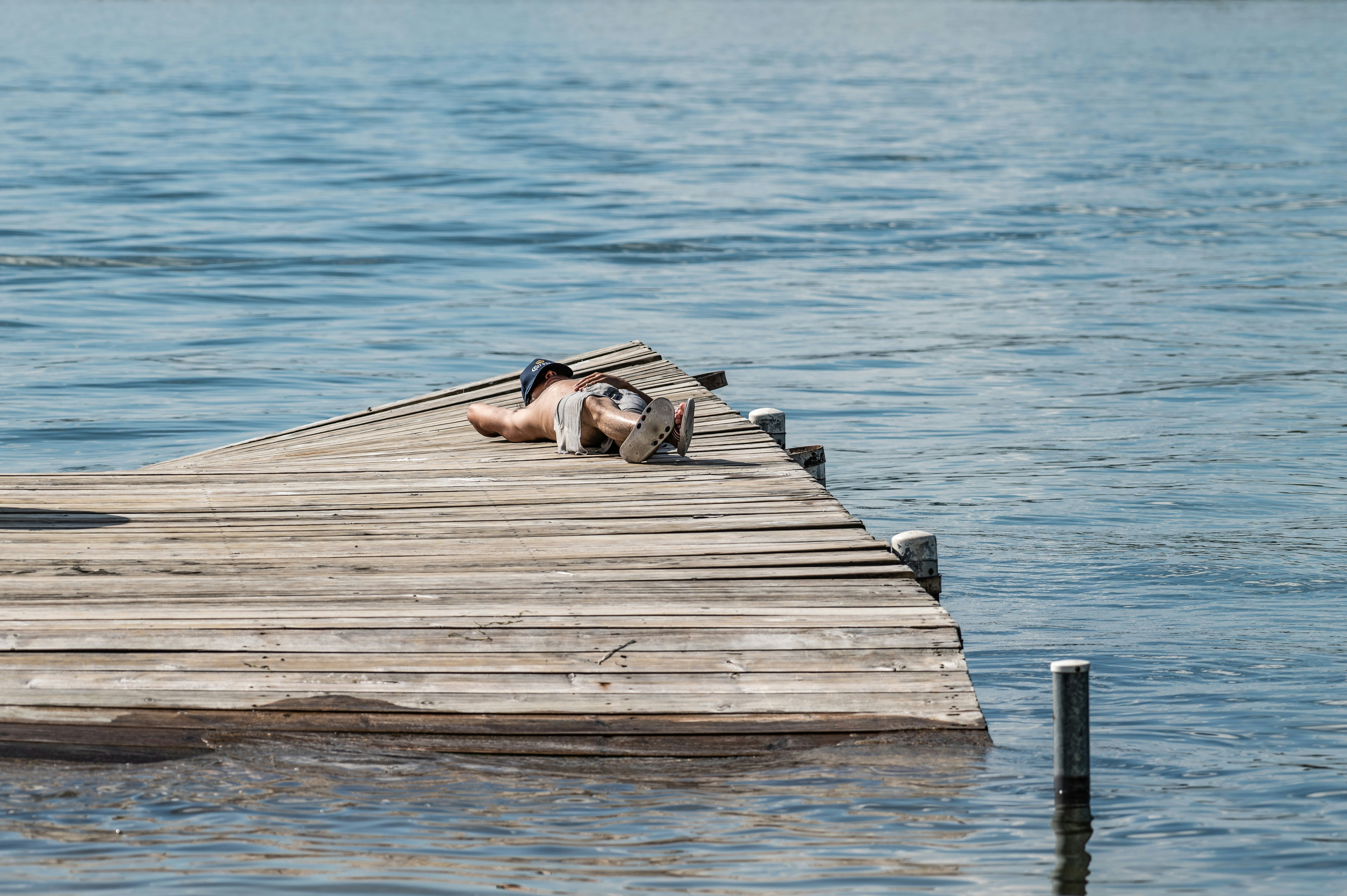 Someone is relaxing and sunbathing on a dock.