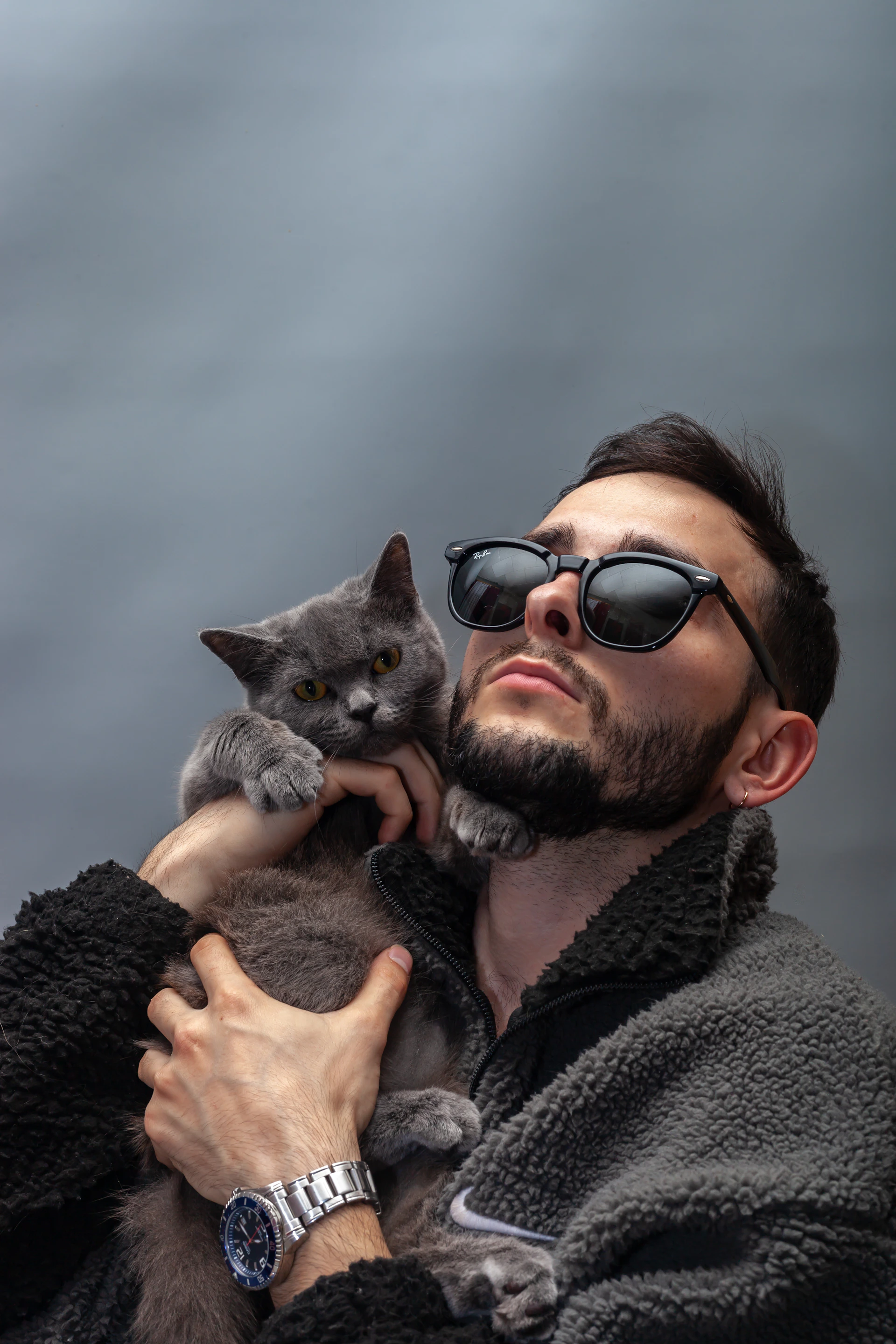 A man holds a gray cat.