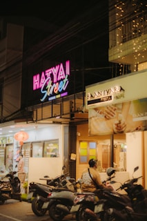 Neon sign illuminates a street in hat yai, thailand.