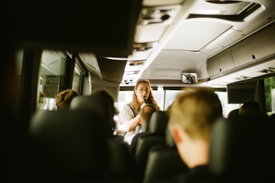 A tour guide is talking to the bus passengers.