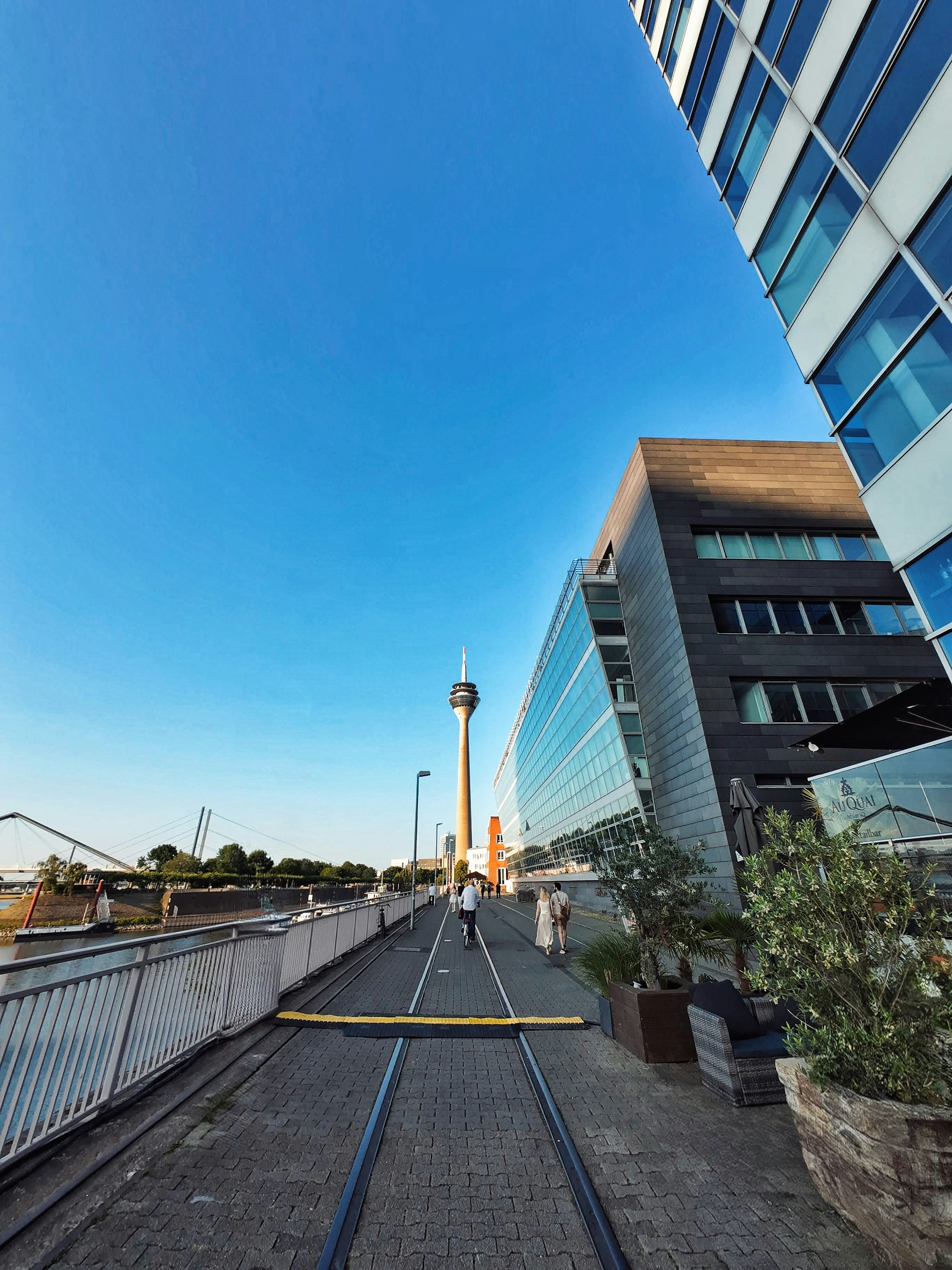 Buildings and a tower against a bright blue sky.