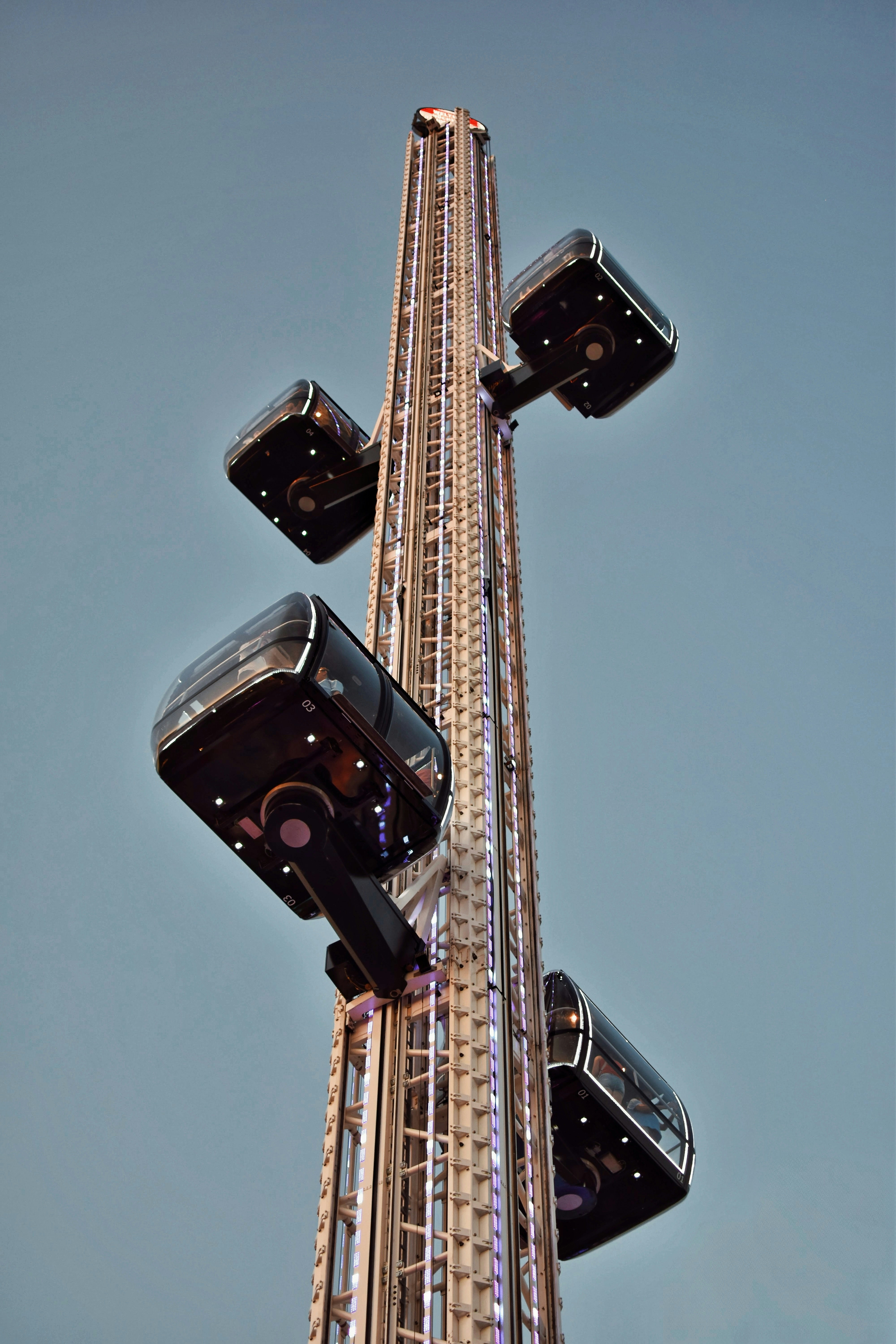 A tall tower ride with passenger pods.