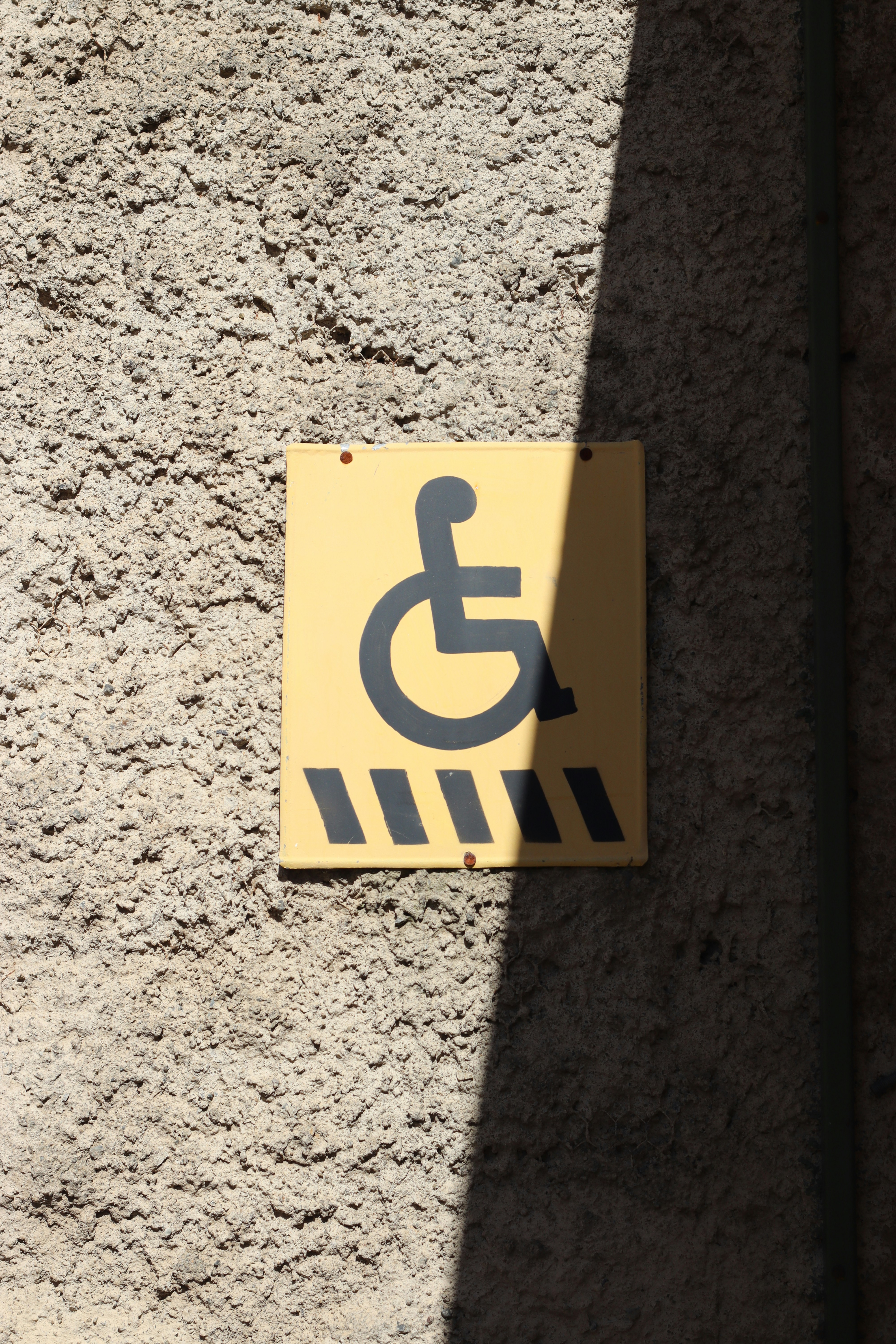 Handicapped parking sign on a textured wall.