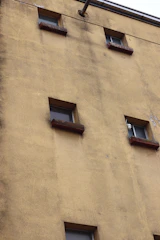 The yellow wall has many windows.
