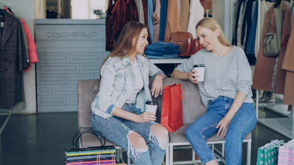 Two women chatting in a clothing store.