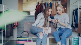 Two women are looking at a phone in a store.